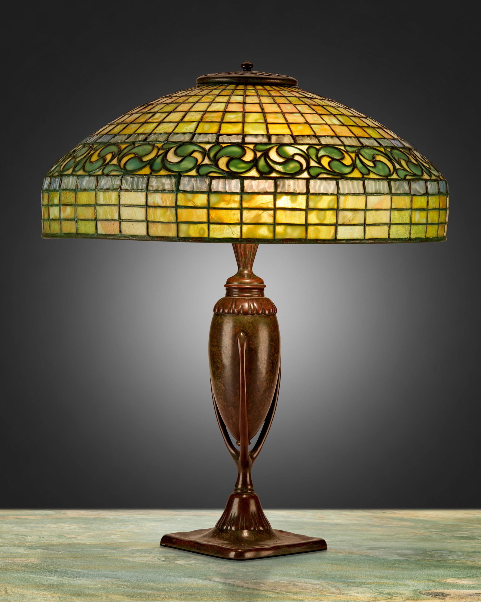 A Tiffany Studios "Vine Border" table lamp: Circa 1902-1919; New York, NY Shade signed: Tiffany Studios / New York / 1470; Base signed: Tiffany Studios / New York / 441 / [T.S. monogram] The green and blue leaded glass "Vine Border" shade on a 