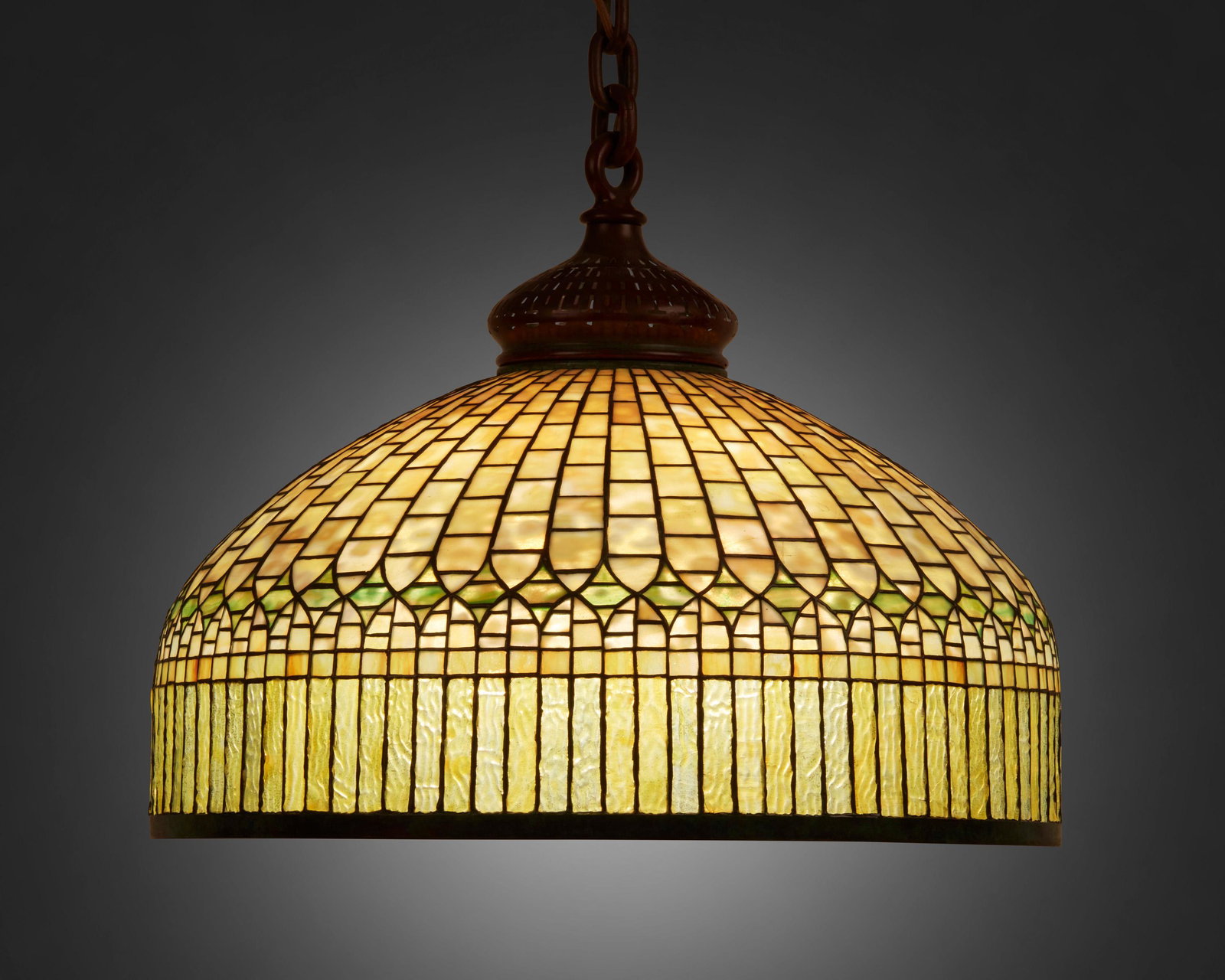 A Tiffany Studios "Curtain Border" hanging lamp: Circa 1902-1919; New York, NY Signed: Tiffany Studios / New York / 1515-39 The yellow leaded glass domical shade with green diamond band and curtain-style border fitted with a six-light socket cluster