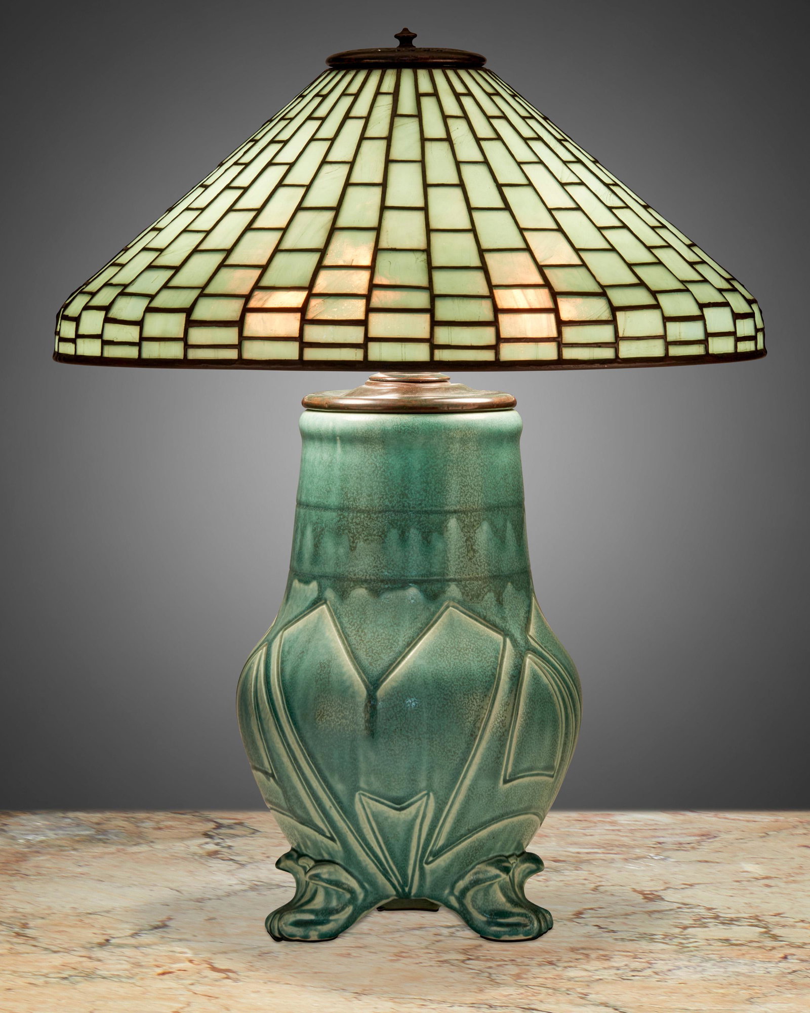 A Tiffany Studios leaded glass and Rookwood pottery: First-quarter 20th Century Shade signed: Tiffany Studios / New York / 1913; Base signed: [Rookwood monogram] / 191 A Z / AM [Albert Cyrus Munson] The aquamarine-colored Tiffany Studios leaded glass co