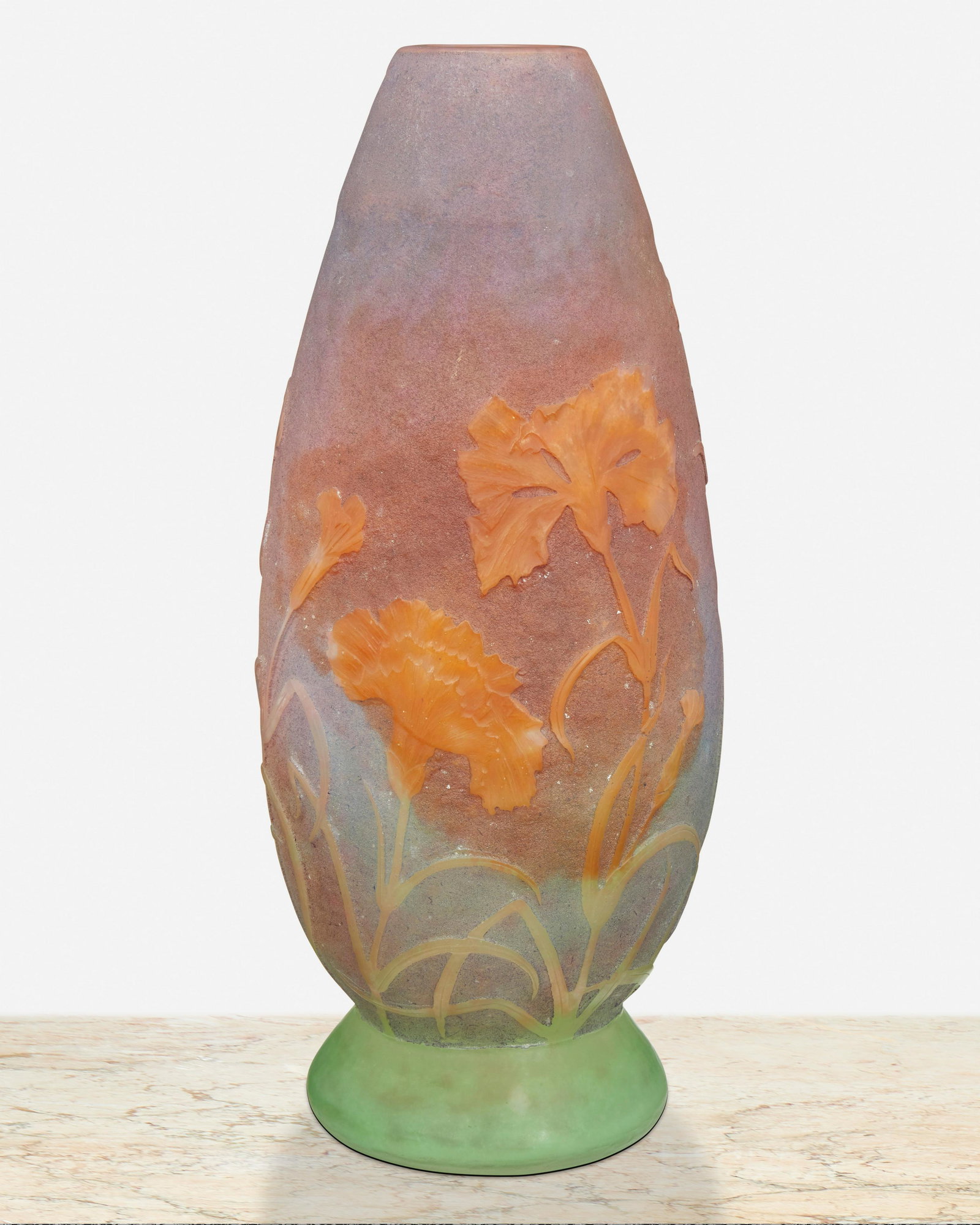 A Daum vitrified cameo glass "Carnation" vase: Late 19th/early 20th Century; Nancy, France Signed: Daum Nancy [Croix de Lorraine] The vitrified and acid-etched cameo glass "Carnation" vase with tapered body cut from green and blue to purple and or