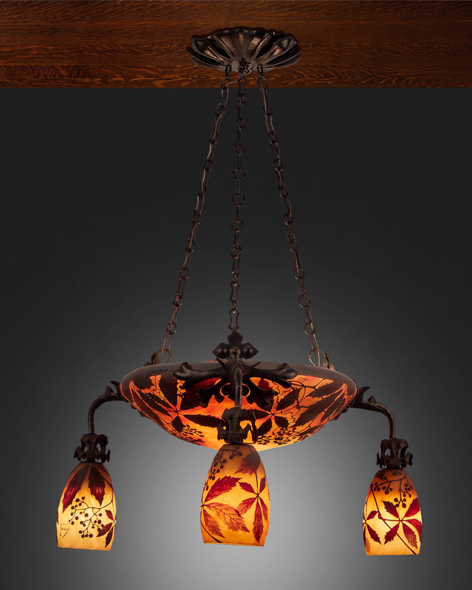 A Daum cameo glass "Wilder Wein" chandelier: First-quarter 20th Century; Nancy, France Signed: Daum Nancy [Croix de Lorraine] The acid-etched cameo glass domical "Wilder Wein" shade with wild vines and berry motifs cut from brown to red and yell