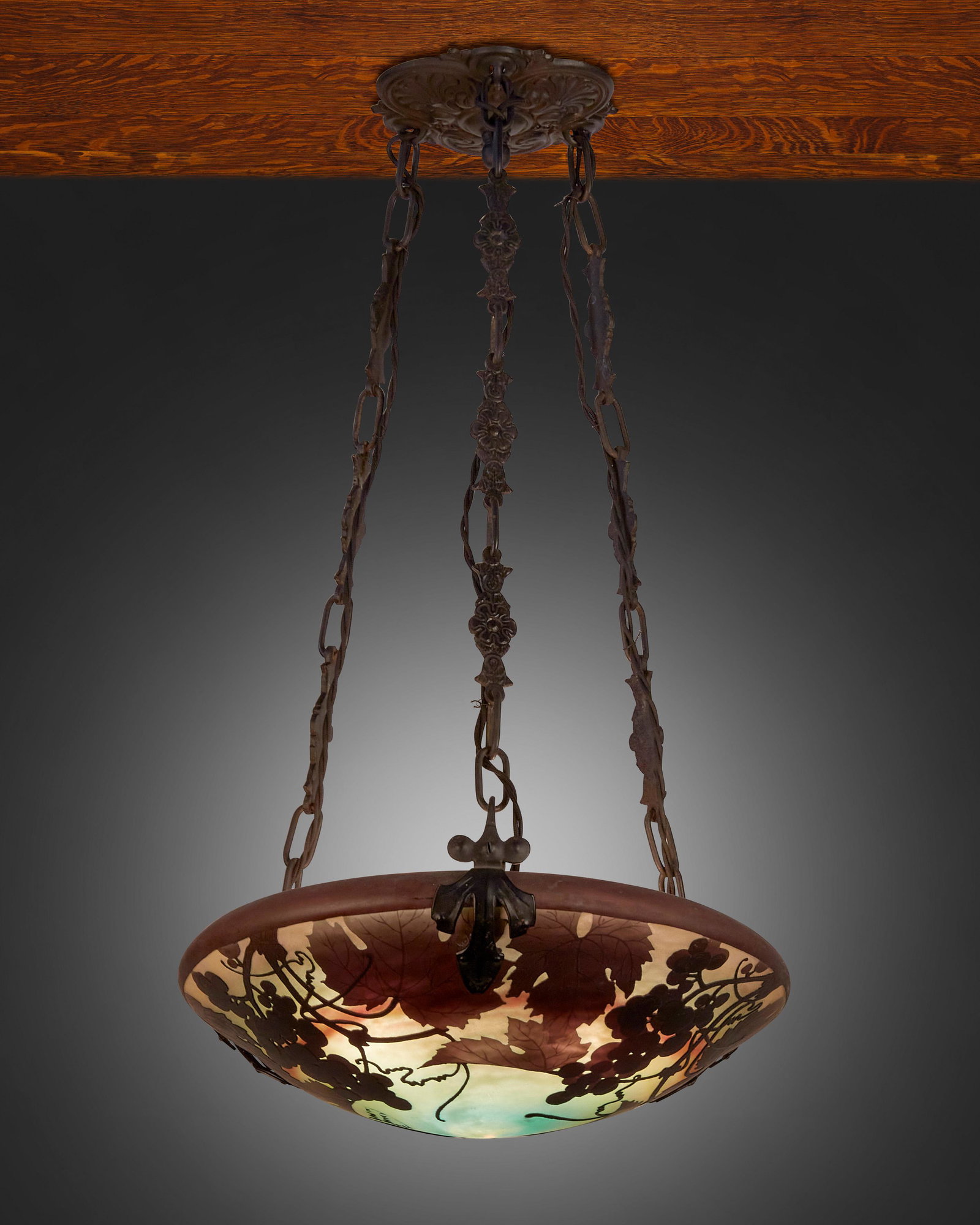 A Daum cameo glass "Grape and Vine" pendant chandelier: First-quarter 20th Century Signed: Daum Nancy [Croix de Lorraine] The acid-etched cameo glass domical shade with grape and vine motifs cut from purple to light green frost fitted with three light sock