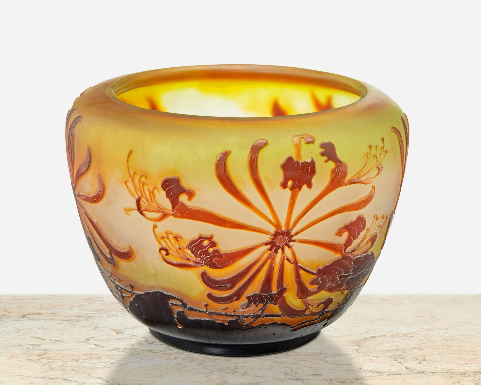 A Galle cameo glass "Honeysuckle" vase: Late 19th/early 20th Century; Nancy, France Signed: Galle The acid-etched cameo glass wide-shouldered "Honeysuckle" vase cut from amber to pale green and white frost 5.25" H x 8" Dia. Provenance: The 