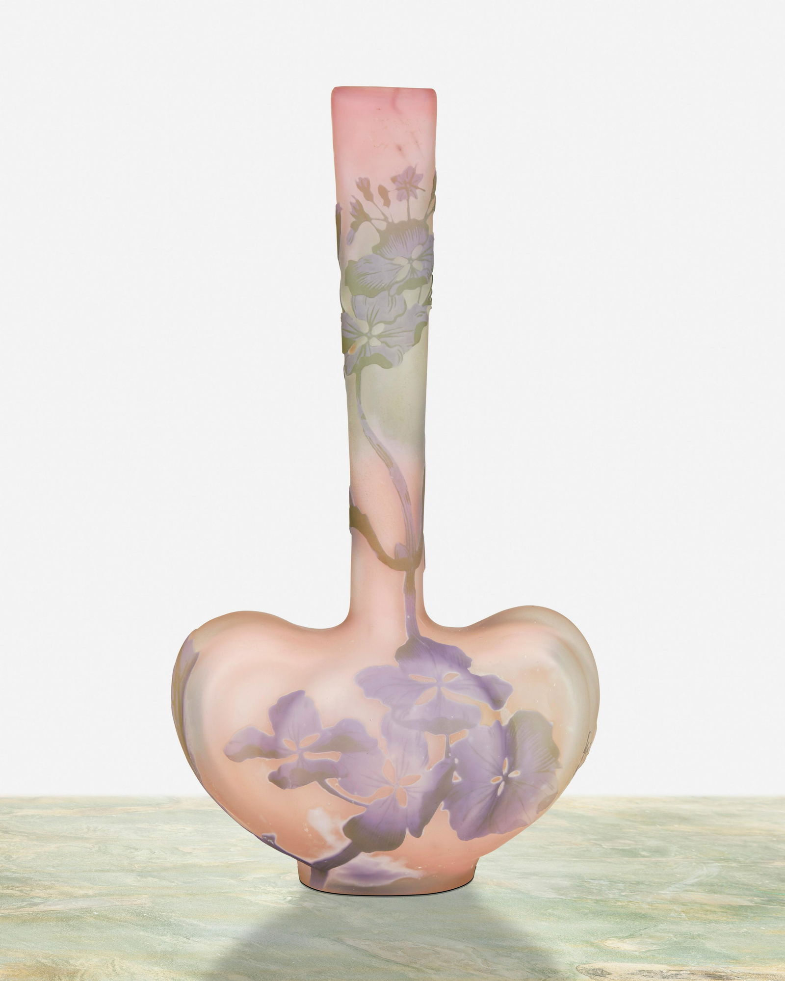 A Galle cameo glass "Hydrangea" bud vase: Circa 1904-1906; Nancy, France Signed: Galle [starred] The heart-shaped acid-etched cameo glass "Hydrangea" vase cut from lavender and light green to pink frost 9.5" H x 5" W x 3.125" D Provenanc