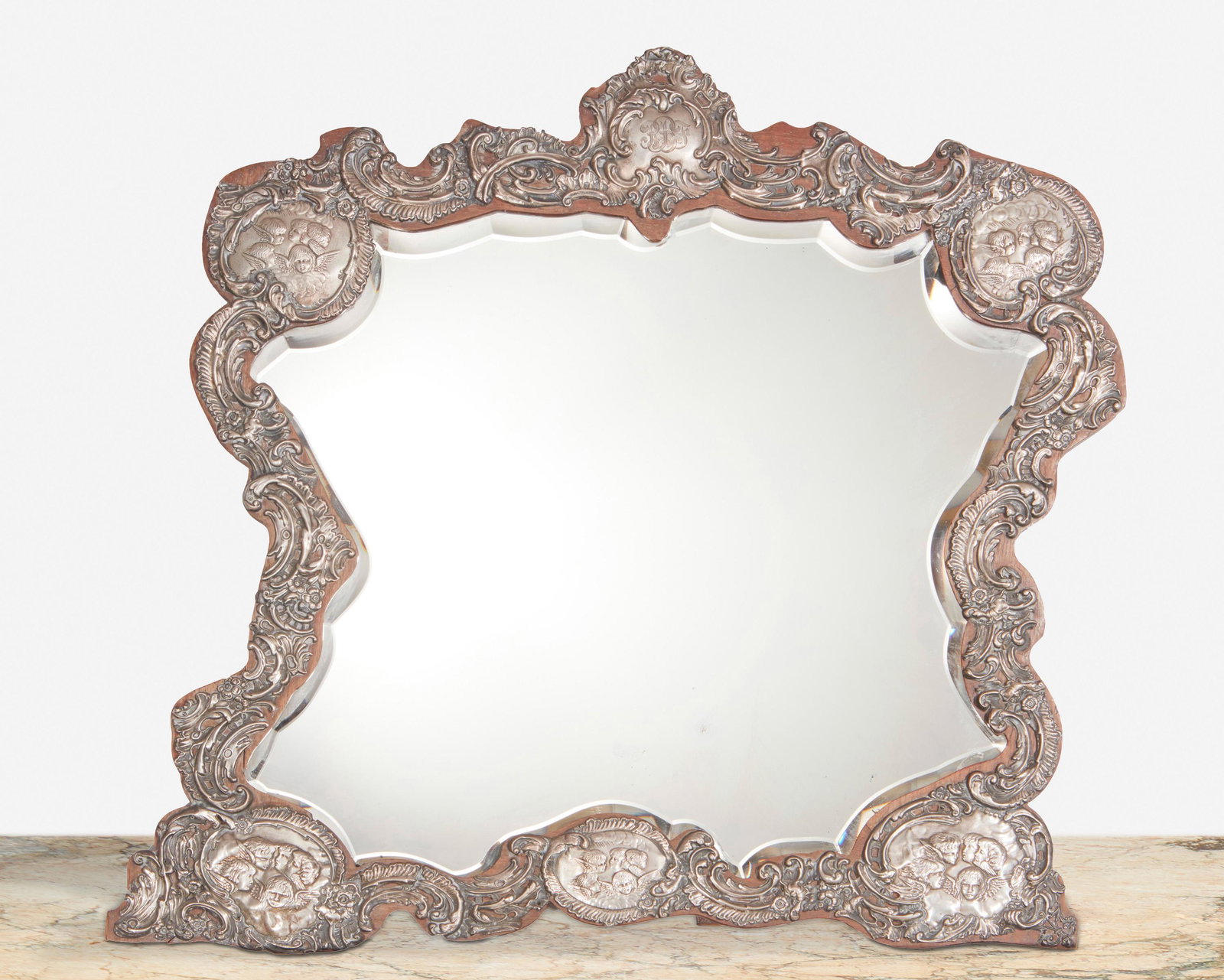 An English sterling silver repousse dressing table: 1904; Birmingham, England Marked for Birmingham; Further marked: JM & Co. [possibly Joseph Moore] The dressing table mirror with sterling silver repousse overlay with scrolling foliage, rocaille, and 