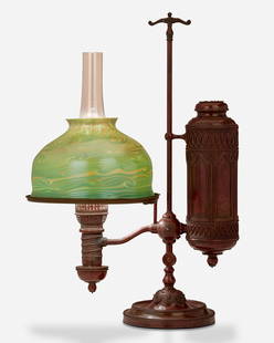 A Tiffany Studios single-arm student lamp: 1902; New York, NY Shade bares signature: L.C.T.; Base marked: 25564 The green and blue iridescent Tiffany-style glass shade on a Gothic-style patinated bronze Manhattan Brass Co. converted oil