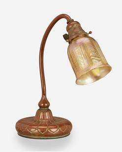 A Tiffany Studios table lamp: Circa 1903; New York, NY Shade signed: L.C.T.; Base signed: Tiffany Studios / New York / [T.G.D.Co. monogram] / 28609 The gold iridescent Favrile glass damascene shade with swirled motif and