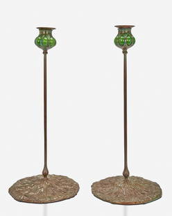 A pair of Tiffany-style candlesticks: 20th Century Each spuriously signed Each with green blown glass capitals and removable bobeches raised on a verdigris patinated bronze base with Queen Anne's lace motif and slender stem, 2