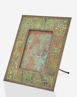 A Tiffany Studios bronze "Pine Needle" frame: Circa 1902-1919; New York, NY Signed: Tiffany Studios / New York / 947 The rectangular verdigris patinated bronze frame with green glass, pine needle motif bronze overlay, and beaded border