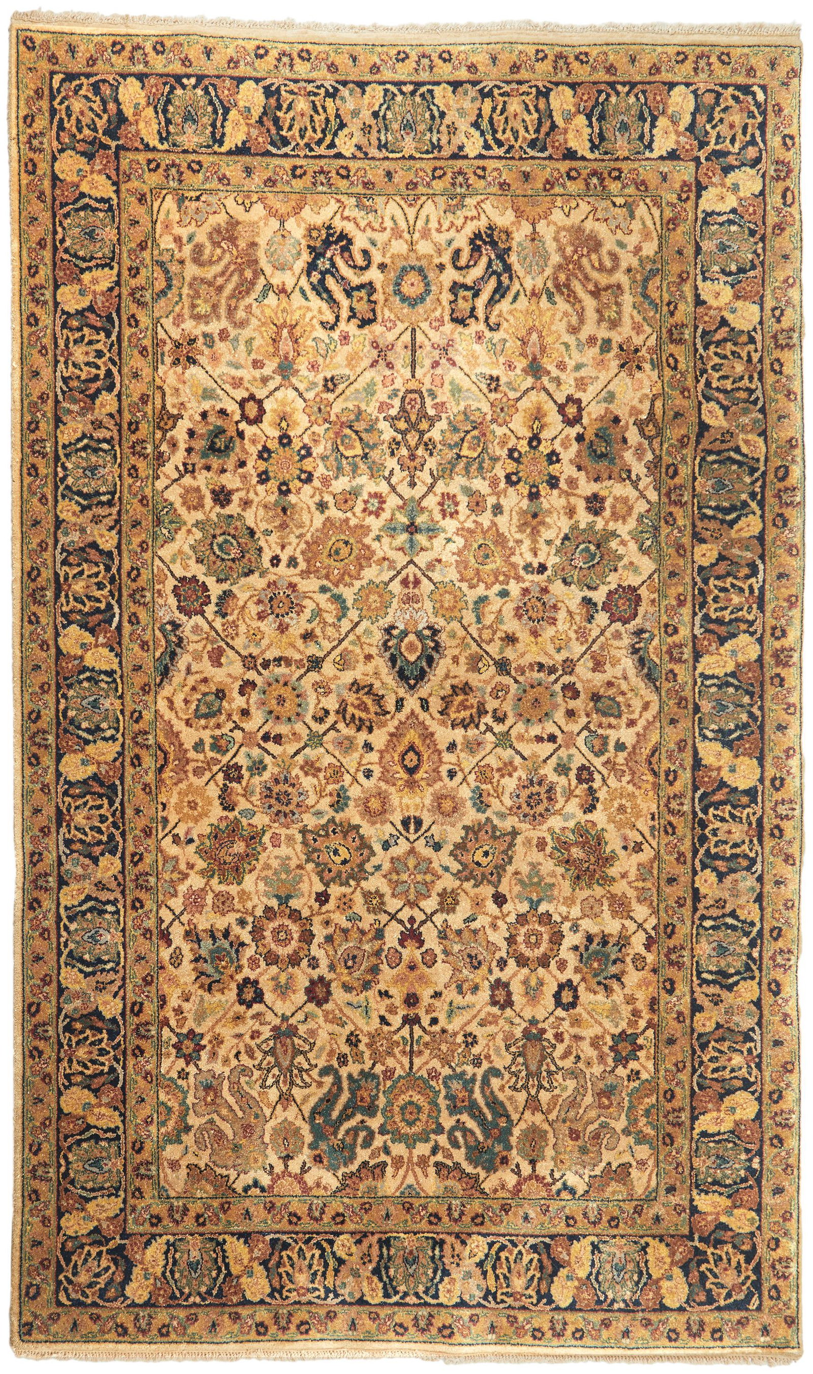 A Persian-style area rug: 20th Century Possibly India, wool on cotton foundation, with all-over polychrome floral and foliate patterning on an ivory ground with a dark blue border 101" L x 67" W