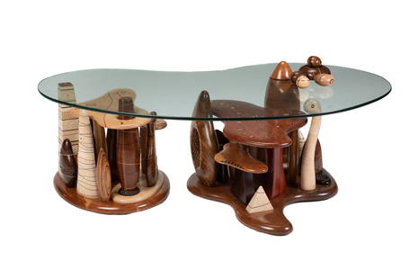 A Steven Spiro cocktail table: 2007  Signed and dated: Spiro / 2007  With a carved hardwood base of various woods in organic and free-form shapes inlaid with mother-of-pearl, a nautilus shell, and moon phase and compass motif marqu