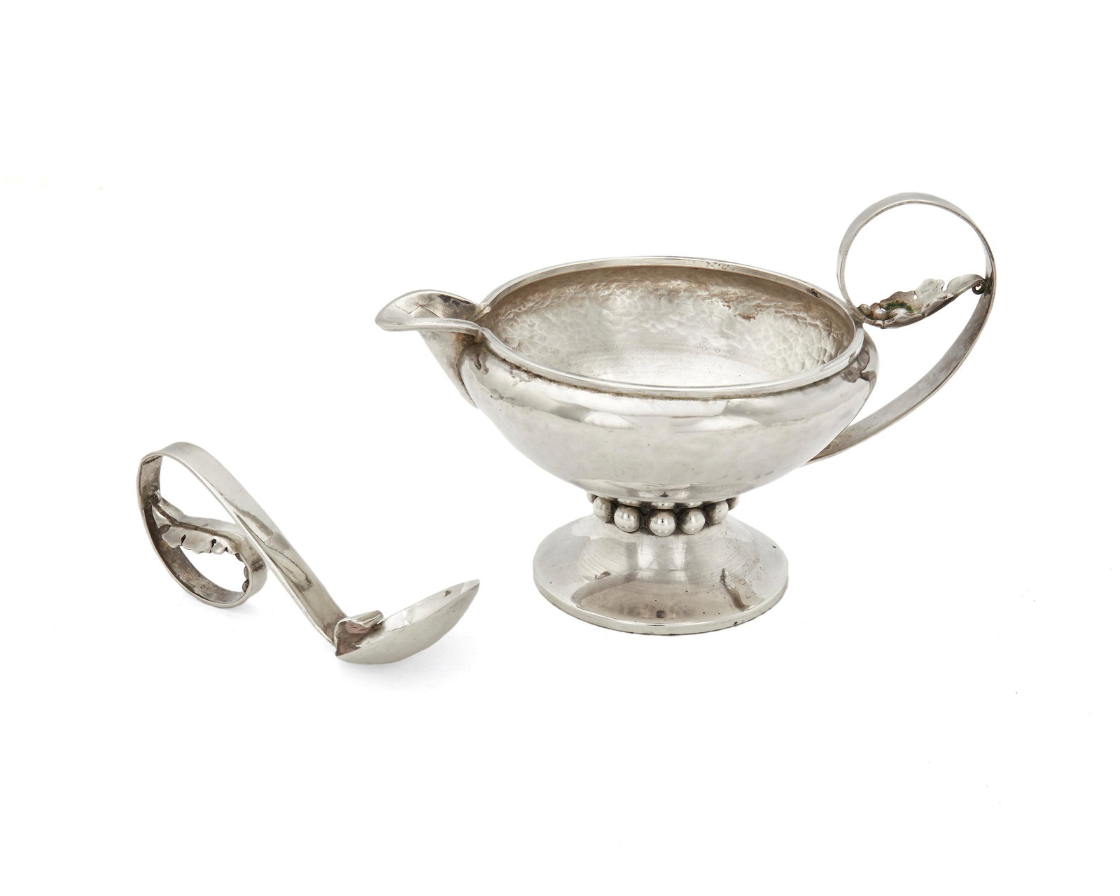 A Los Castillo silver sauce bowl and ladle: Circa 1948-1955; Taxco, Mexico Each marked: Los Castillo / Taxco / Handwrought / Eagle 15 / Sterling / Mexico; Bowl numbered: 101; Ladle numbered: 119 The hand-hammered sterling silver bowl with scrol