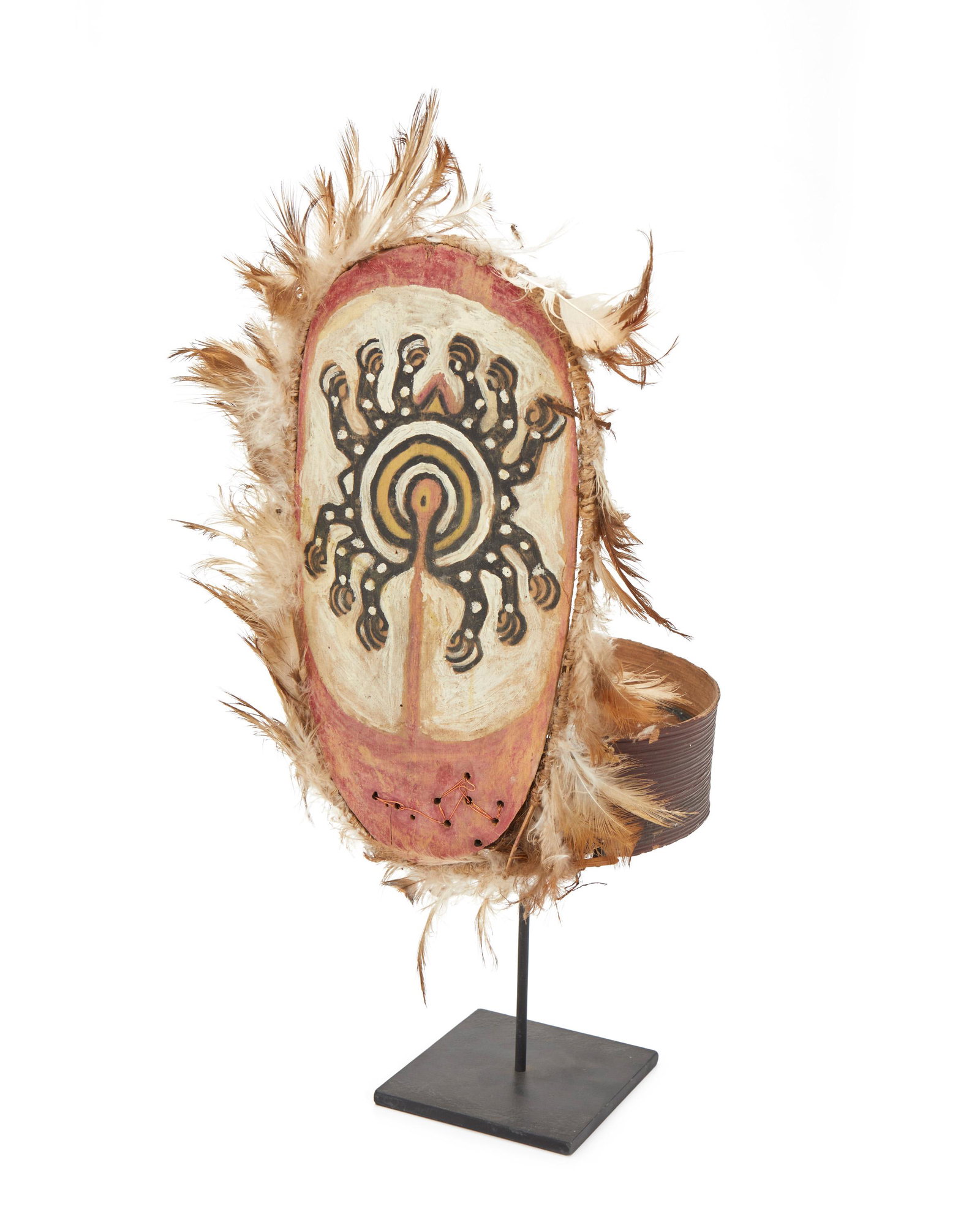 A Gogodala headdress: 20th Century; Gogodala people, Papua New Guinea The polychromed wood headdress adorned with feathers mounted on metal base 14" H x 6.375" W x 7" D approximately