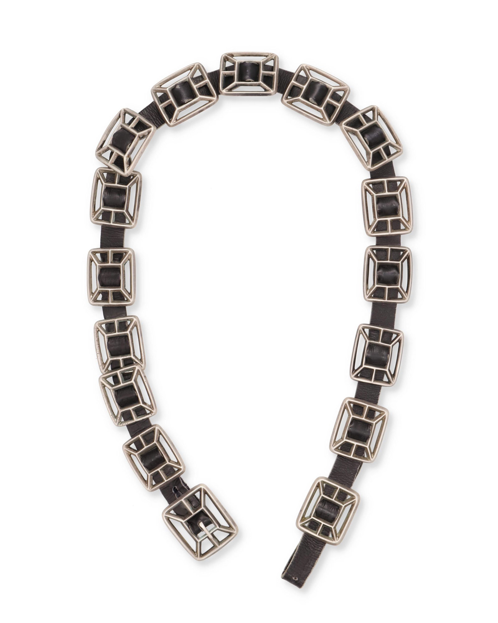 A Southwest sandcast concho belt: Mid-20th Century Designed with fifteen sandcast geometric conchos (each: 1.25" H x 1.45" H) and one matching belt buckle (1.25" H x 1.75" W) attached to a black leather belt Leather belt: 33.5" L 218 