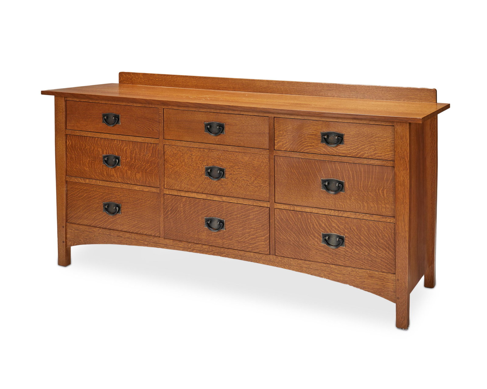 A contemporary Stickley "Harvey Ellis" dresser: Circa 1990s; Manlius, NY With Stickley burned mark and metal factory tag The oak Arts and Crafts-style dresser with a raised back rail and a rectangular top over nine short drawers with copper pulls, 