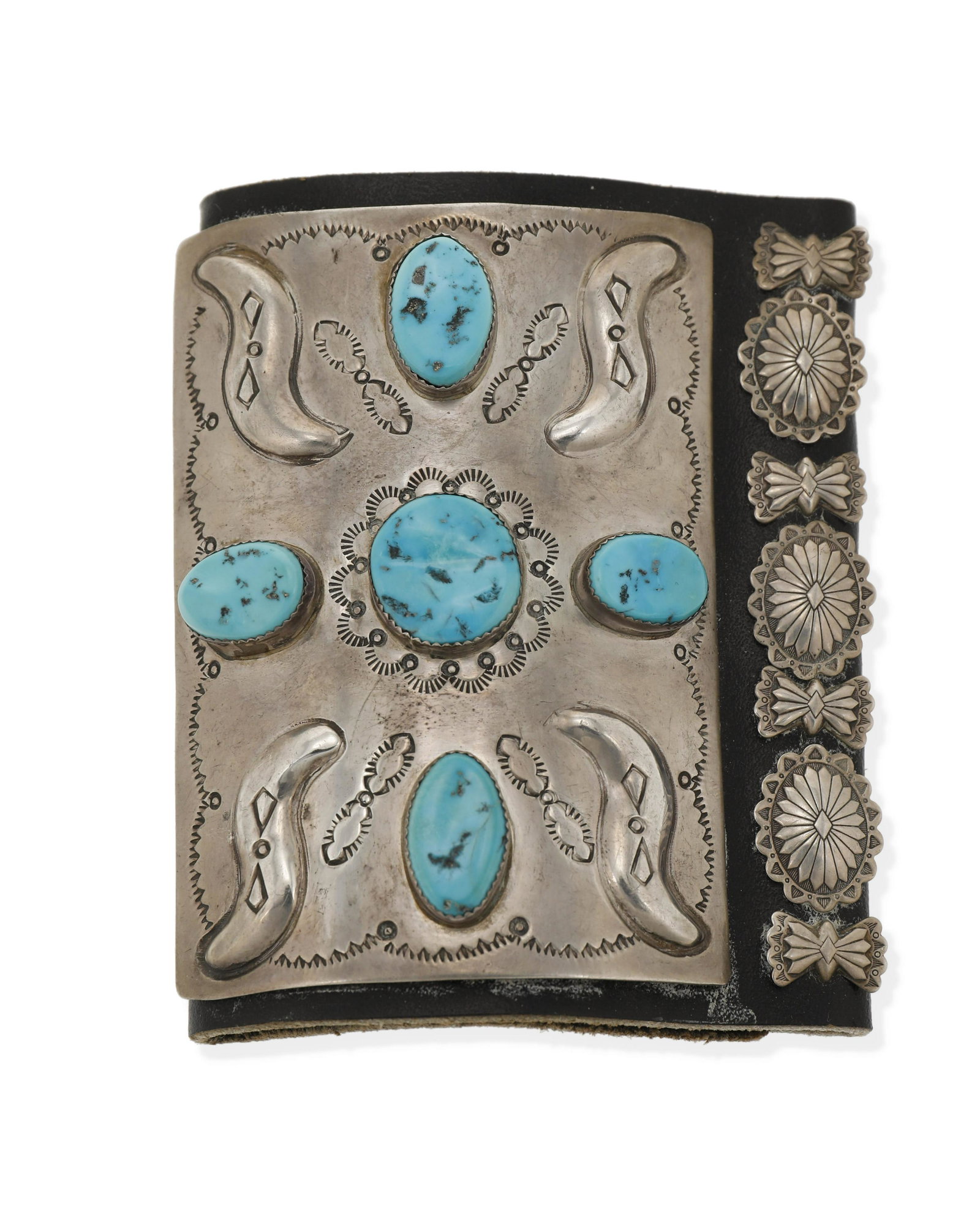 A Navajo silver and turquoise ketoh arm guard: Second-Half 20th Century, Dine Stamped with conjoined WAT; Further stamped: IHMSS [for Indian Handmade Sterling Silver] A ketoh with a repousse and stamped central plaque set with five turquoise stone