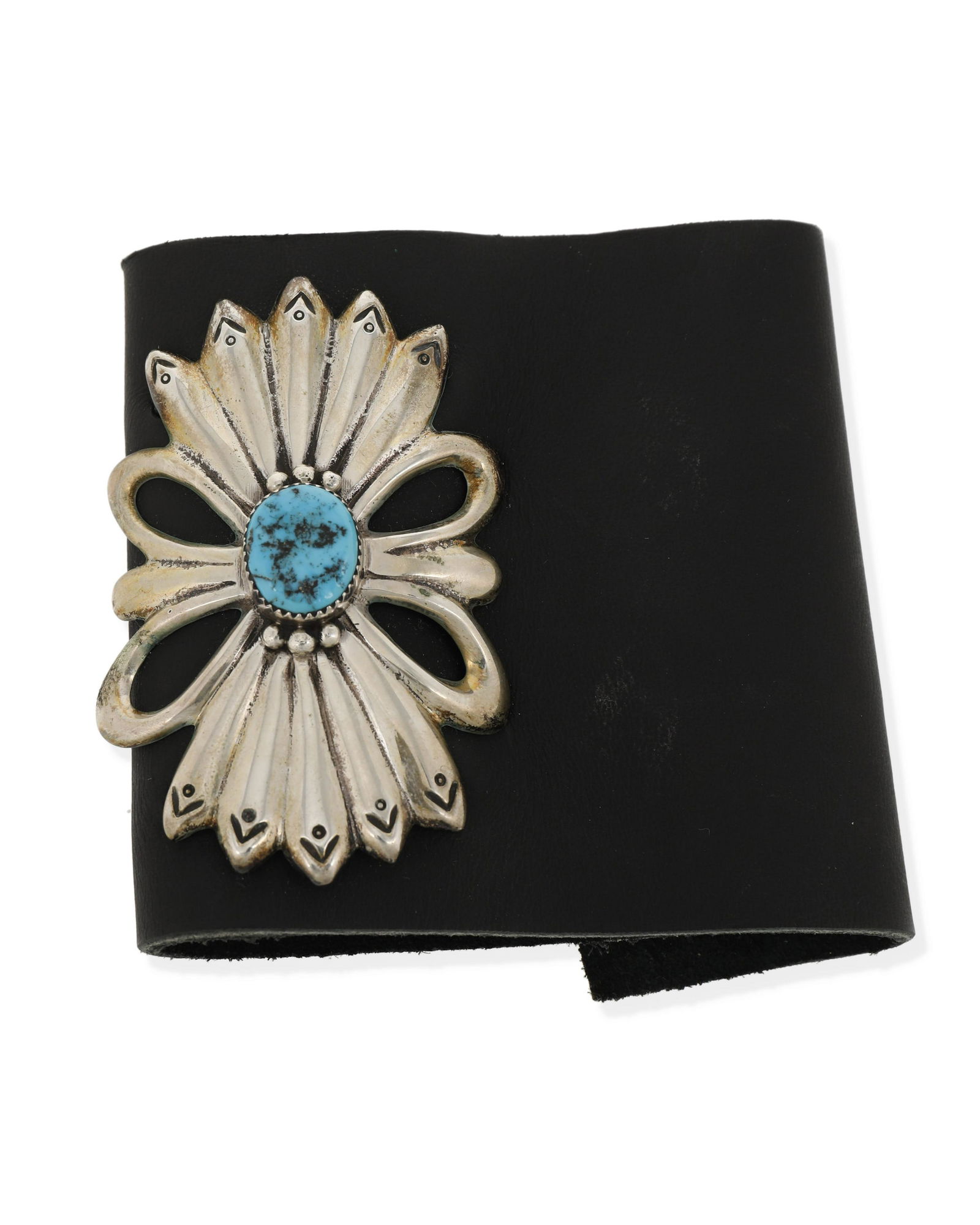 A Navajo silver and turquoise ketoh arm guard: Fourth-Quarter 20th Century, Dine Appears unmarked A ketoh with a cast butterfly motif with central sawtooth bezel set turquoise stone, all tightly attached to a black leather strap with leather tie
