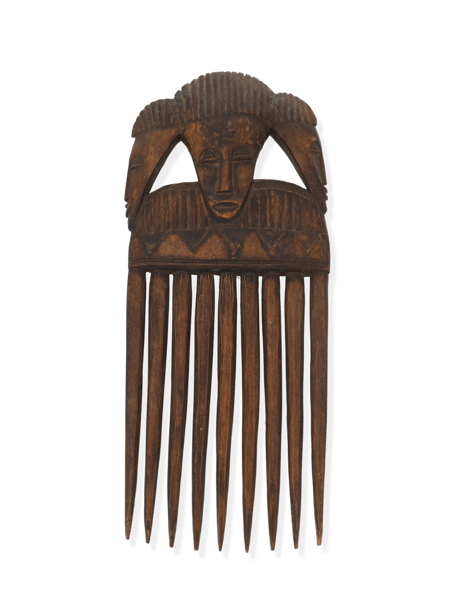 A West African carved wood comb: 20th Century With the handle in the form of three faces 9.5" H x 4" W x 0.5" D Provenance: Purchased by present owner in 1988