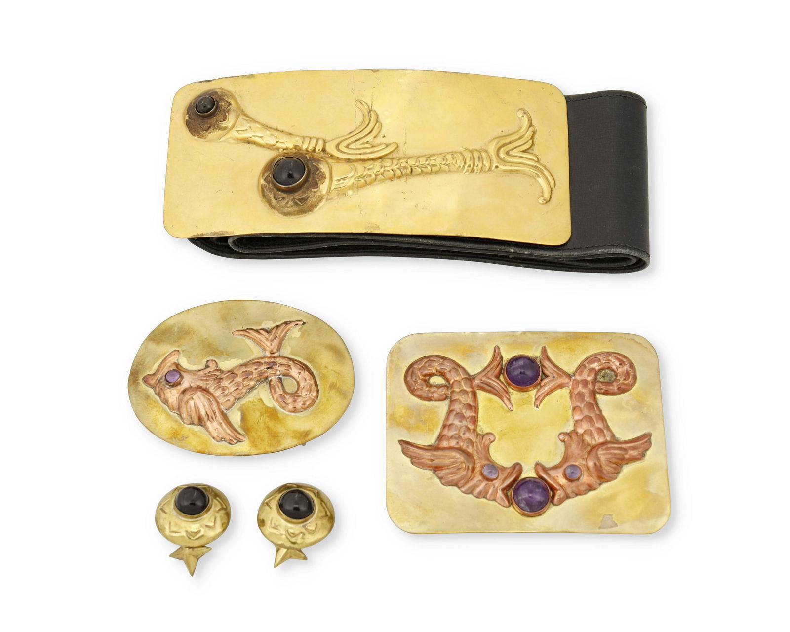 A group of Hubert Harmon brass and copper buckles and: 1942-1948; Mexico Four works: A brass buckle with an applied copper repousse double fish motif set with amethysts Stamped: Hubert Harmon / Mexico 3.25" H x 4.25" W An oval brass buckle with an