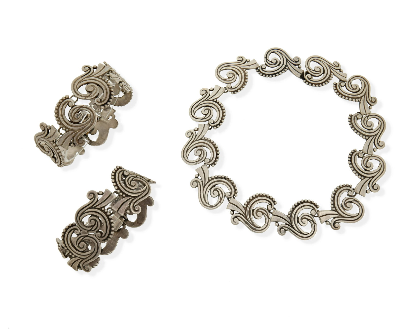 A set of Los Castillo silver jewelry: 1942-1948, Taxco, Mexico Each stamped: Los Castillo / Taxco / Sterling / Made in Mexico / 615 Necklace further stamped: A Comprising a segmented necklace with arabesque openwork motifs (15" L x 1.125"