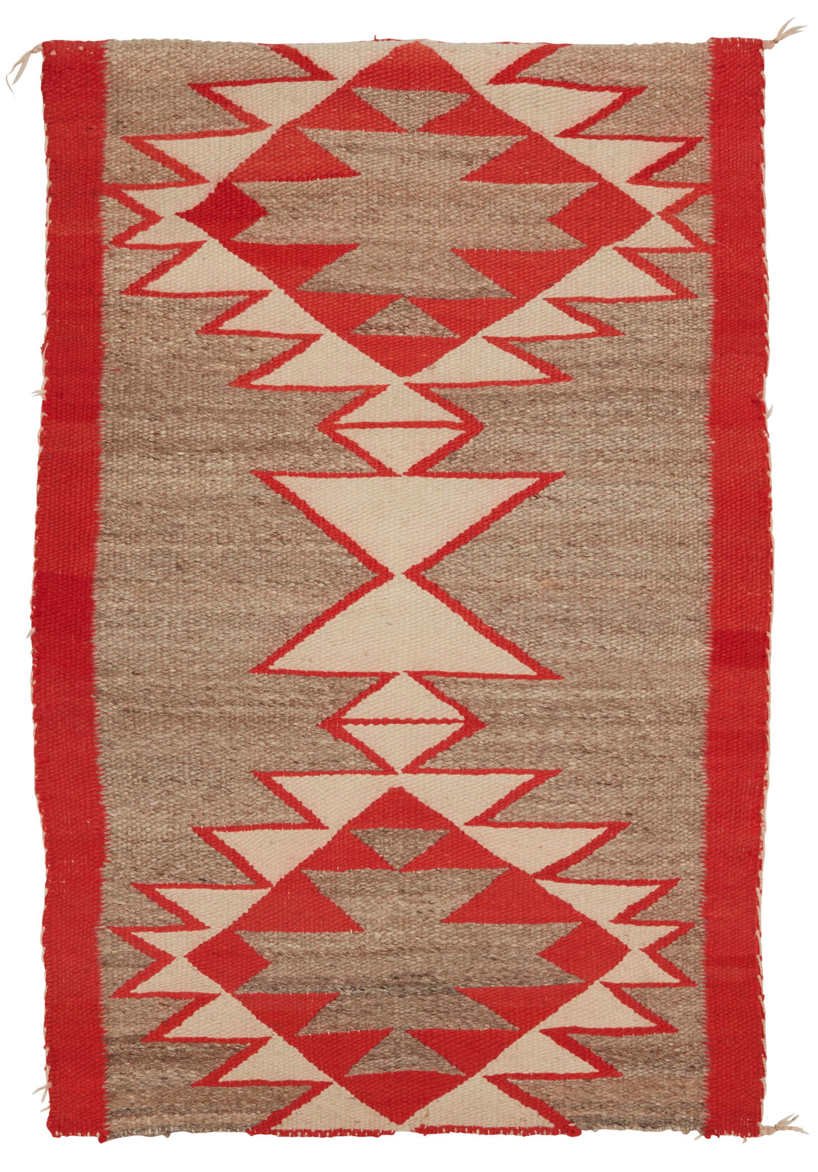 A Navajo regional rug: First-Quarter 20th Century Woven in grey, cream and red wool, with conjoined serrated diamond motif 42.5" H x 27" W