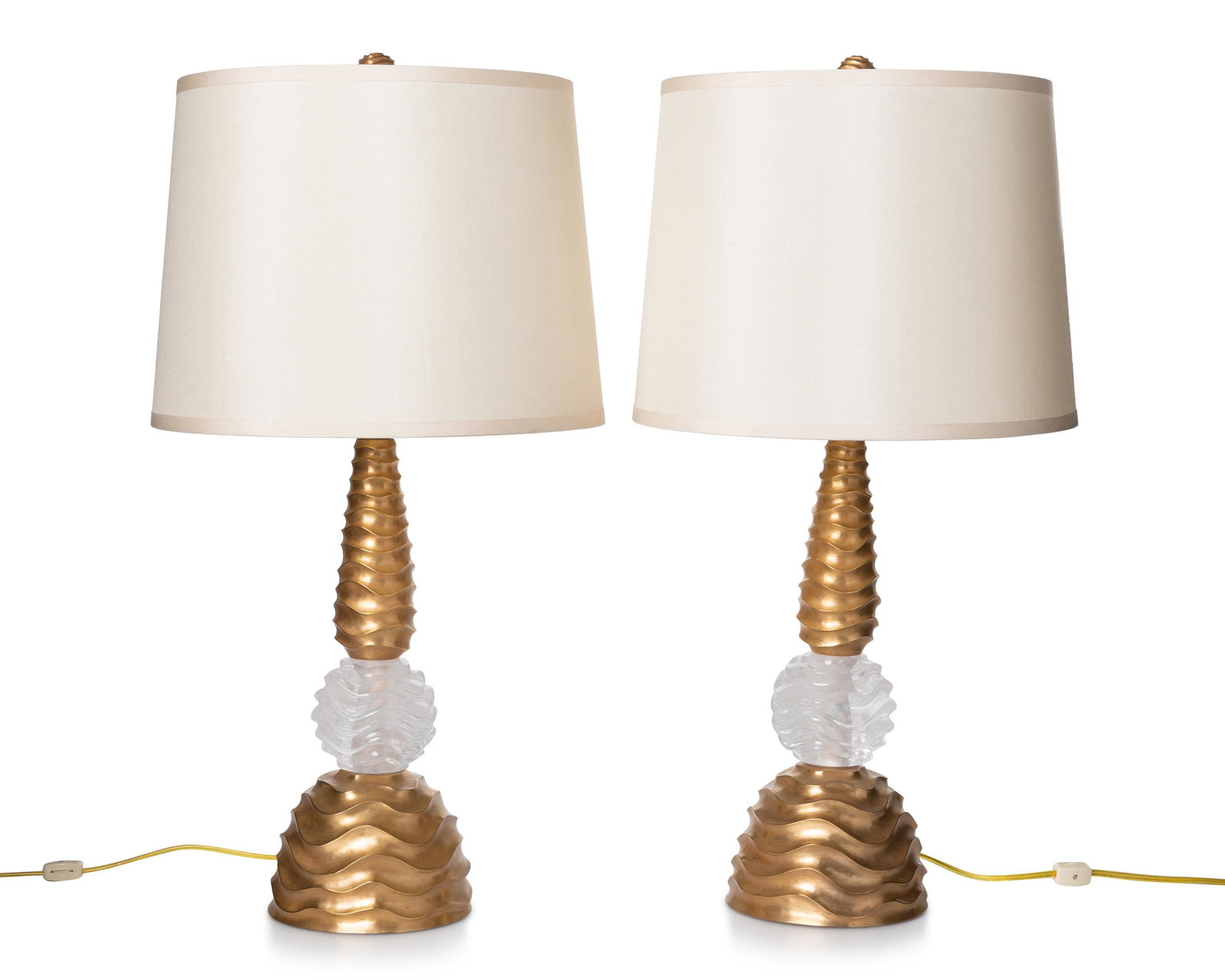 A pair of contemporary table lamps: 21st Century Each table lamp with a gilt-metal base centering a clear rock crystal sphere, all with a wave-style surface design, and fitted with ivory silk shades, electrified, 2 pieces Each overall: 