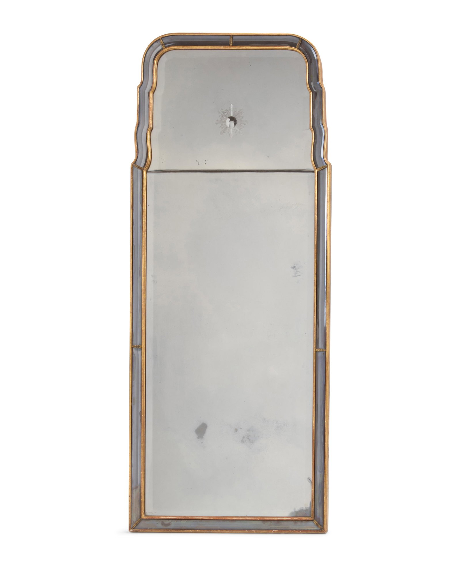A Hollywood Regency-style wall mirror: Mid-20th Century With giltwood frame with light amethyst mirrored channel inset with beveled mirror in two sections, with upper center bullseye starburst 56.25" H x 23.25" W x 1.25" D Provenance: The 