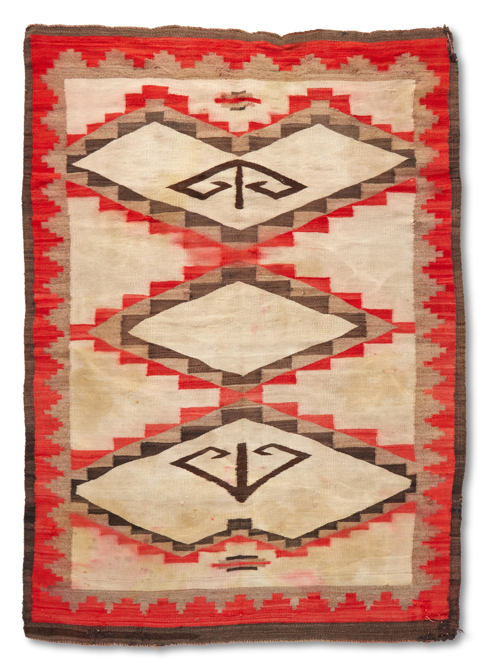 A Navajo regional rug: 20th century; Dine Woven in red, cream, grey and black wool, with a central stepped diamond and lozenges 86" L x 59" W