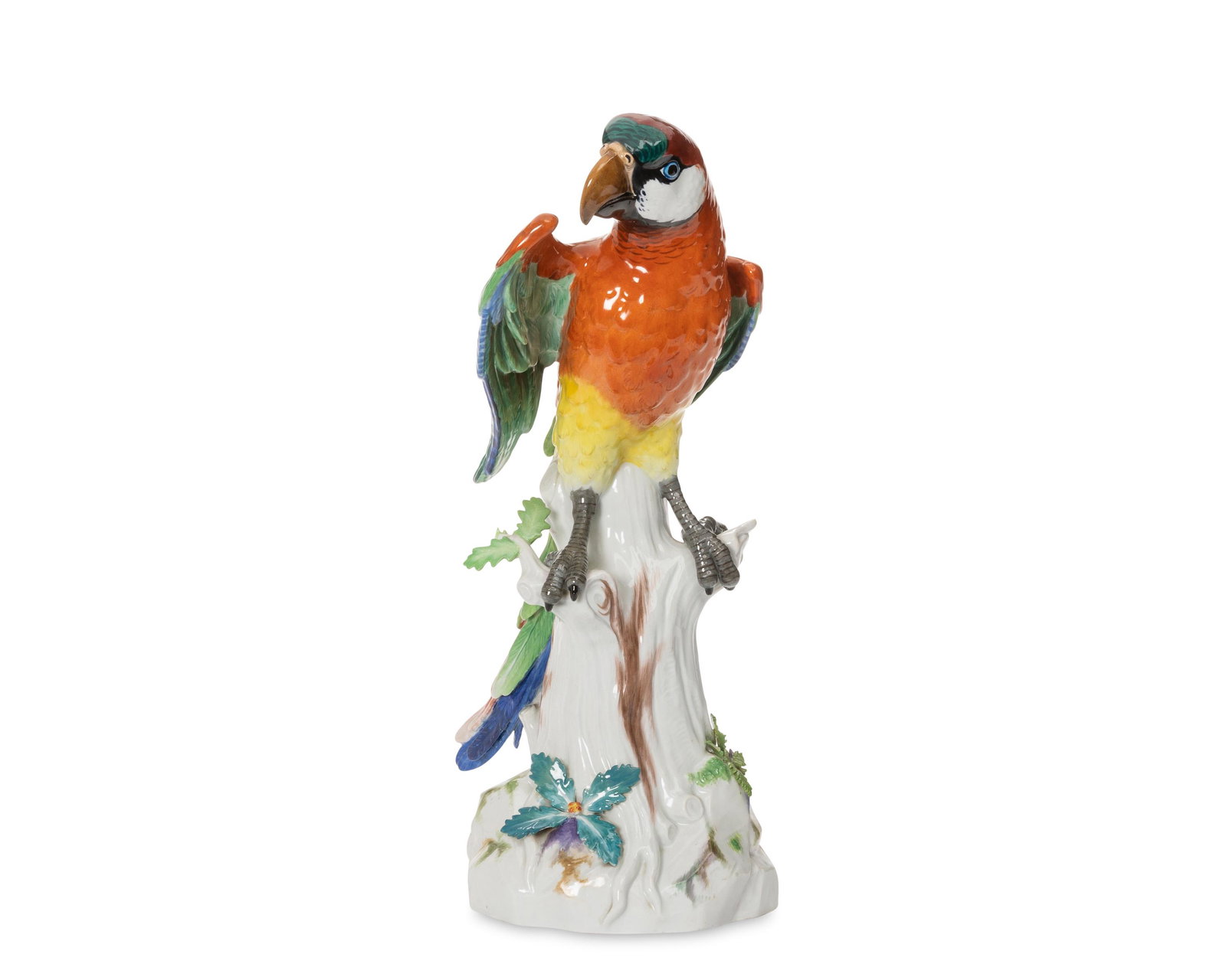 A Meissen porcelain parrot figure: Circa 1947-73 Marked for Meissen [blue crossed swords]; inscribed: A436 The glazed porcelain parrot with red, green, yellow, and blue feathers perched on a tree stump 16.25" H x 6.25" W x 8.25"D