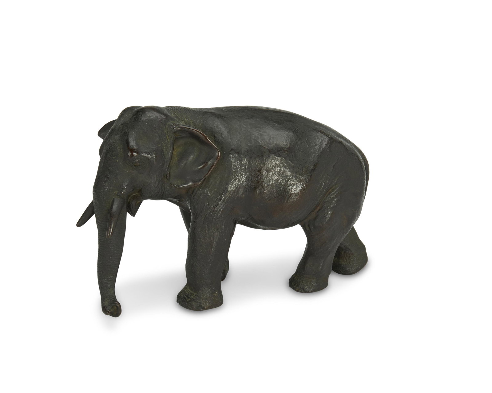 A Japanese okimono bronze elephant: Late 19th century Signed in the casting with characters at the underside The naturalistically modelled elephant, or "okimono," in patinated bronze 4.75" H x 2.75" W x 7" D Provenance: The Estate of Ge