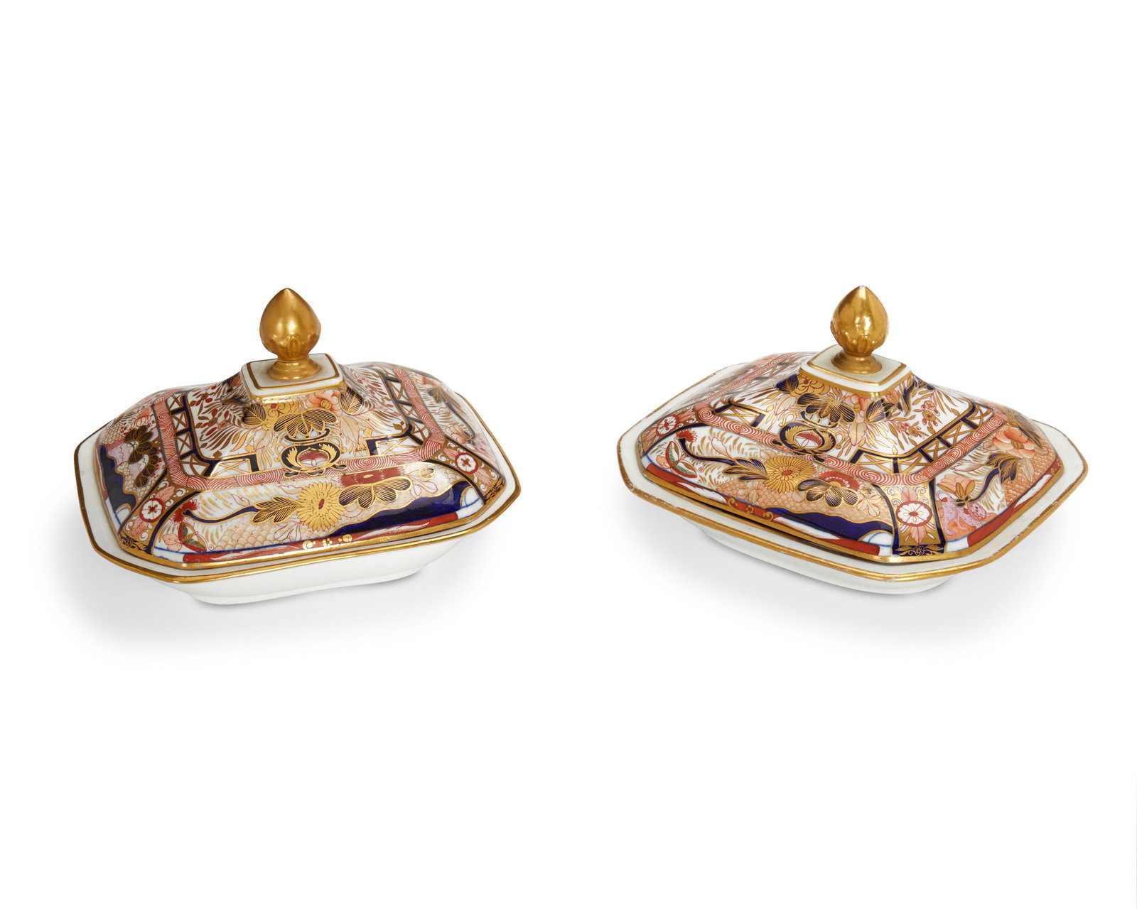 A pair of Japanese Imari porcelain lidded dishes: Late 19th century; Japan Each Kinrand-style with foliate, monkey, and crane motifs and gilt touches throughout the design; completely gilt finial on each lid, 2 pieces Each: 6" H x 9.5" L x 8.25" W