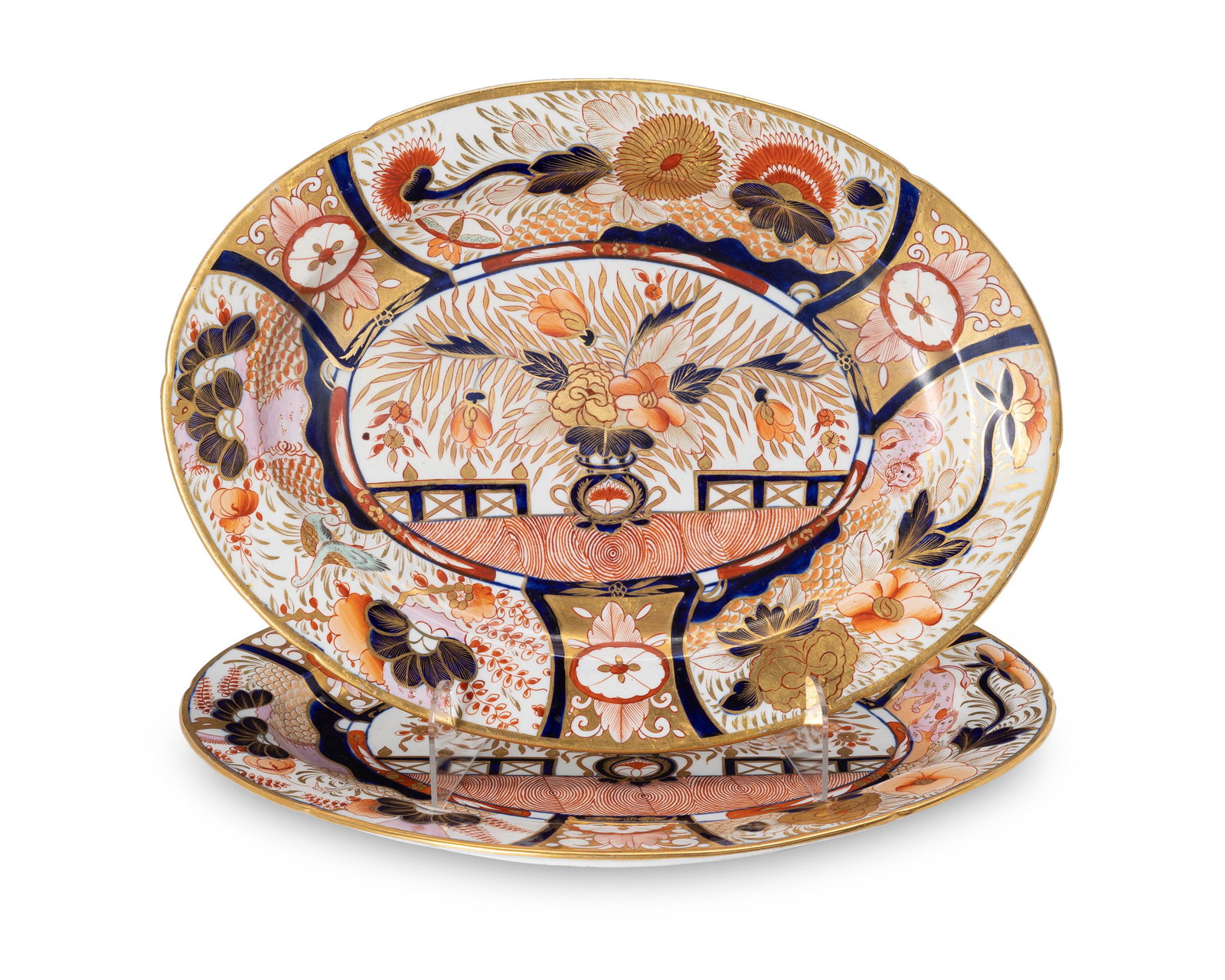 A pair of Japanese Imari porcelain oval serving dishes: Late 19th Century; Japan Each marked with an embossed '6' to the underside Each Kinrand-style with foliate, monkey, and crane motifs and gilt touches throughout the design, 2 pieces Each: 1.125" H x 1