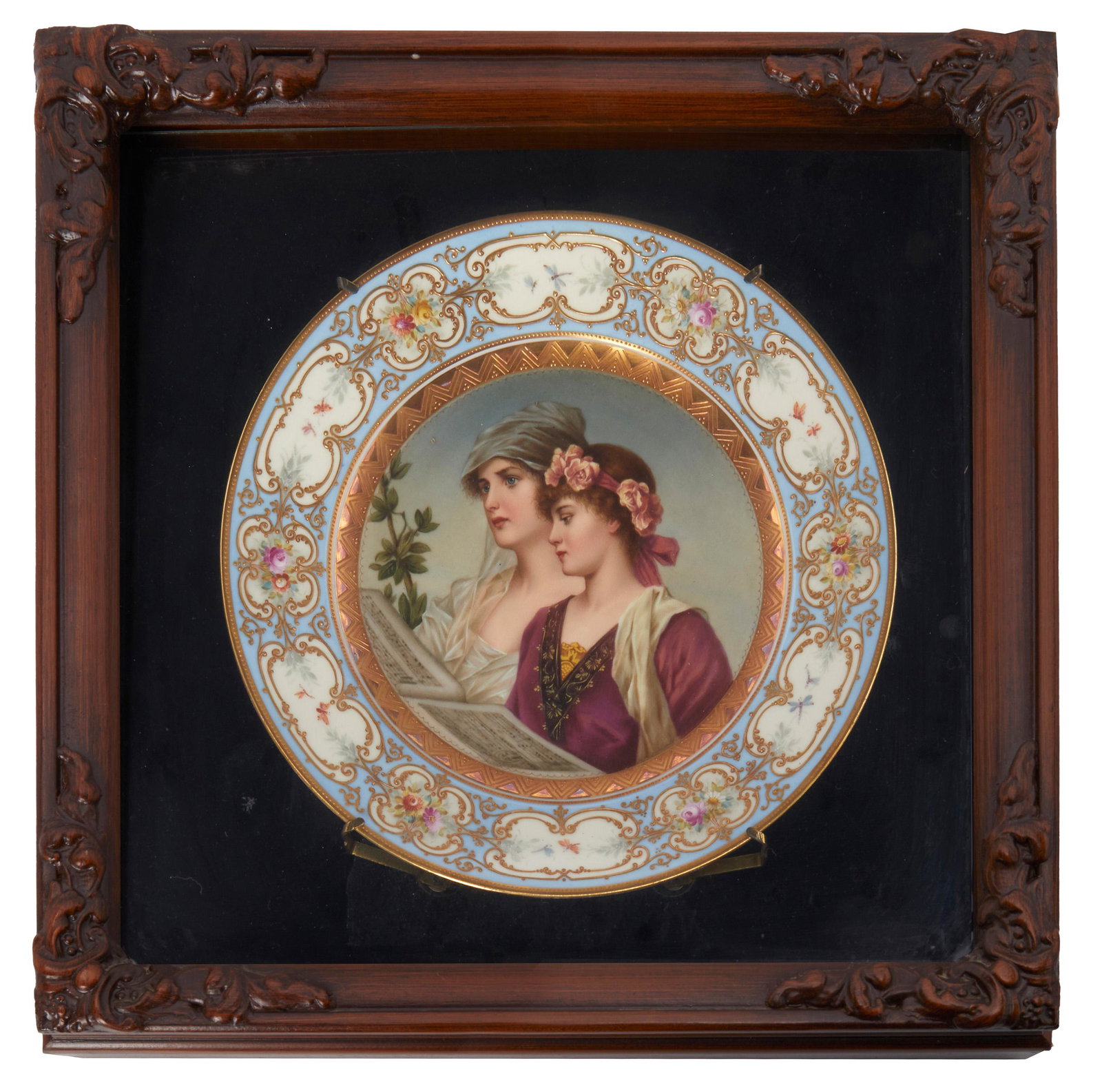 A Royal Vienna porcelain portrait plate: Late 19th/early 20th century Marked with blue underglaze Bindenschild; further inscribed: Duett The porcelain plate with a blue and enamel gilt rim decorated with medallions of floral swags centering 