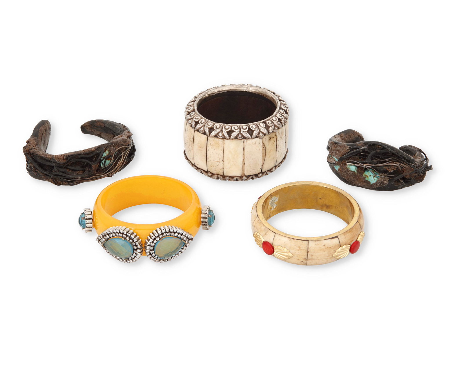 A mixed group of bracelets: A mixed group of bracelets Late 20th century Largest bone bangle marked: DD Comprising five bracelets including a mustard yellow resin bangle with applied diamante stones, a pair of organic formed woo