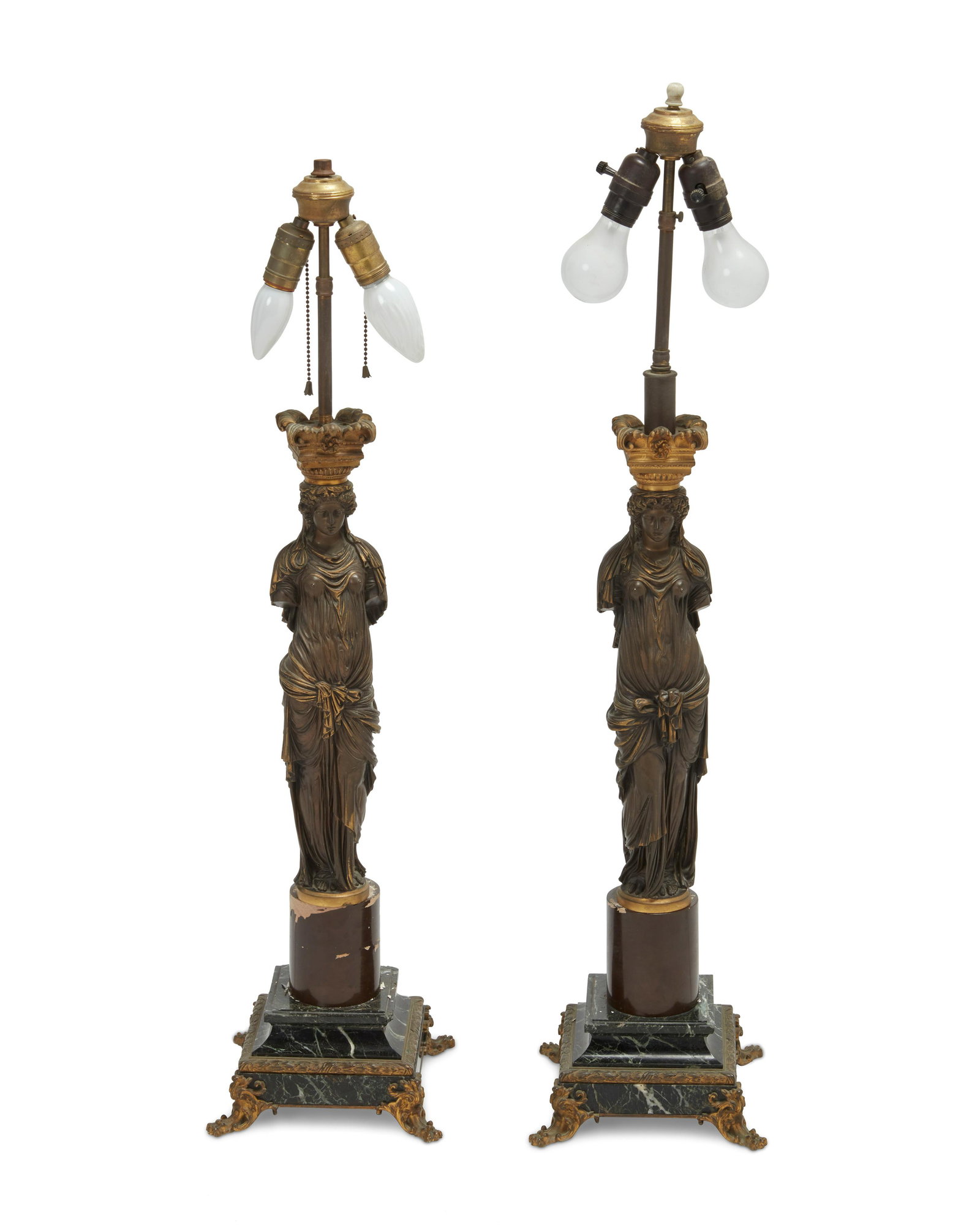 A pair of French gilt bronze caryatid lamps: A pair of French gilt bronze caryatid lamps Late 19th century; France Each with the "Reduction Mecanique a Collas Brevete" medallion stamped on the back of the figures Two dual socketed lamp
