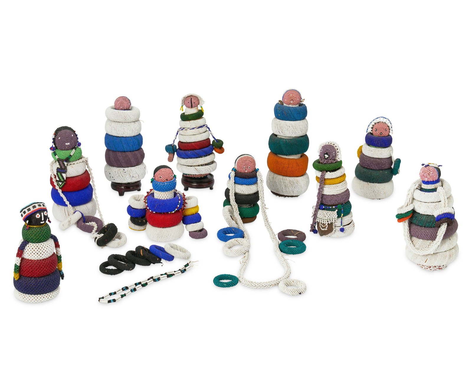 A group of Ndebele beaded fertility dolls: A group of Ndebele beaded fertility dolls 20th century; Zimbabwe, South Africa Each appears unmarked Comprising ten different "fertility" dolls, each with cylindrical wooden bodies, wrapped 