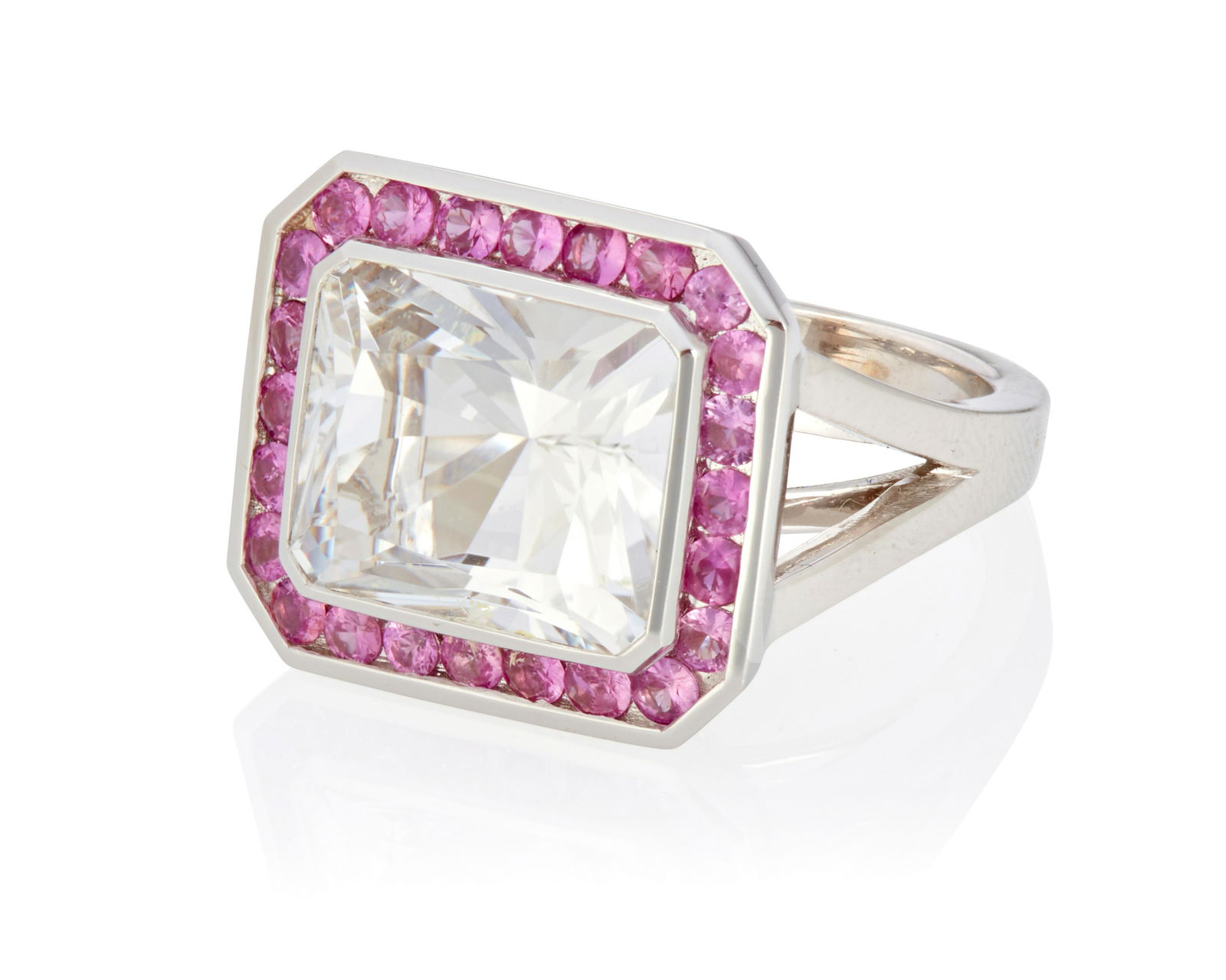 An aquamarine and pink sapphire ring: An aquamarine and pink sapphire ring18k white gold; Stamped: CA / 750Centering a bezel set fancy-cut aquamarine gauged at 13mm x 11mm x 7.6mm surrounded by twenty-four round mixed-cut pink sapphires t