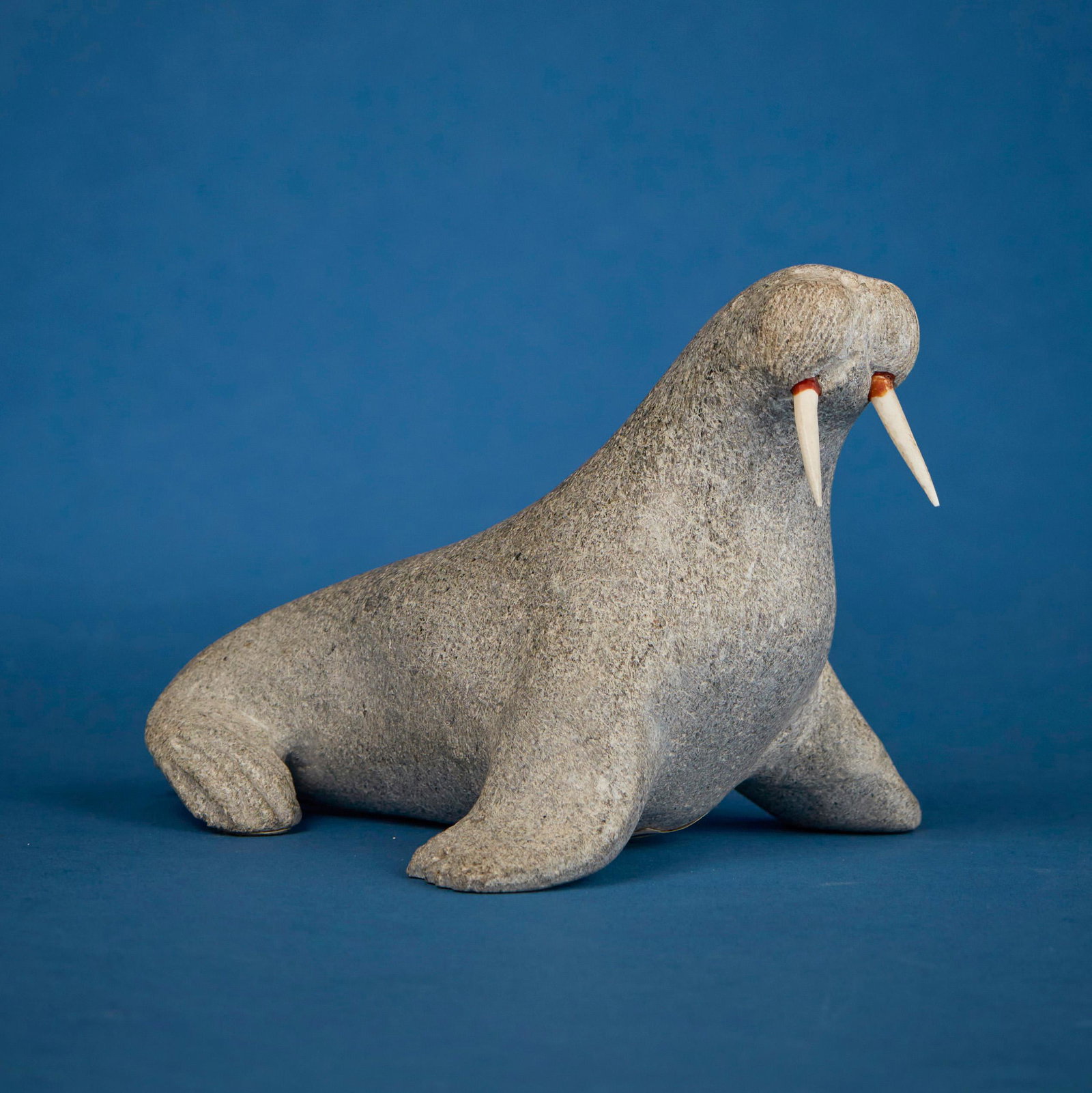 John Kaunak (b. 1941, Inuit; Repulse Bay/Naujaat), Carved walrus with tusks: Y John Kaunak (b. 1941, Inuit; Repulse Bay/Naujaat) Carved walrus with tusks Stone and bone Signed to underside: John Kaunak / Repulse Bay / N.W.J.; further marked with sticker: Canada eskimo art 4.62