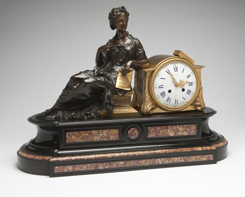 A Napoleon III gilt and patinated bronze, marble : Fourth quarter 19th century, the dial signed ''LeRoy / a Paris'', the movement unsigned, the circular white enamel dial with Roman numeral chapters and Arabic minute divisions within an arched case to