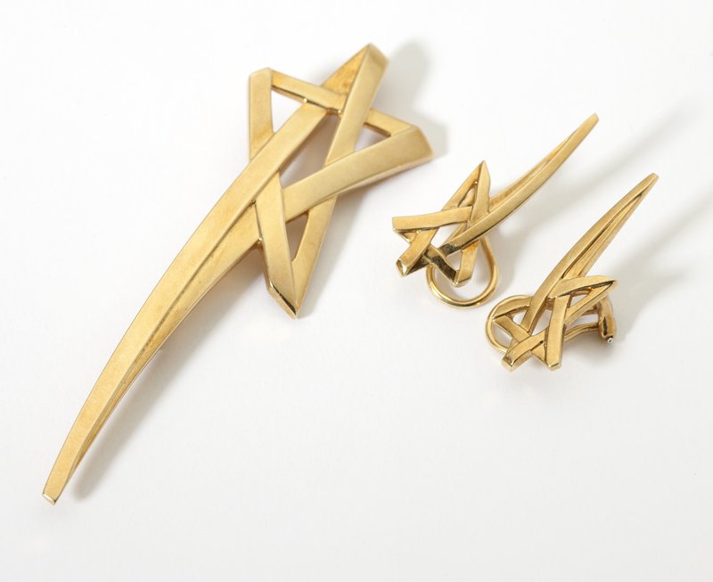 A gold brooch and matching earrings, Paloma Picas: Signed ''Paloma Picasso, Tiffany & Co'', 18K, with a pair of matching ear clips with star motif, 28.5 gms, 3 pcs, , est:$1000/1500. Provenance: Estate, Beverly Hills, CA