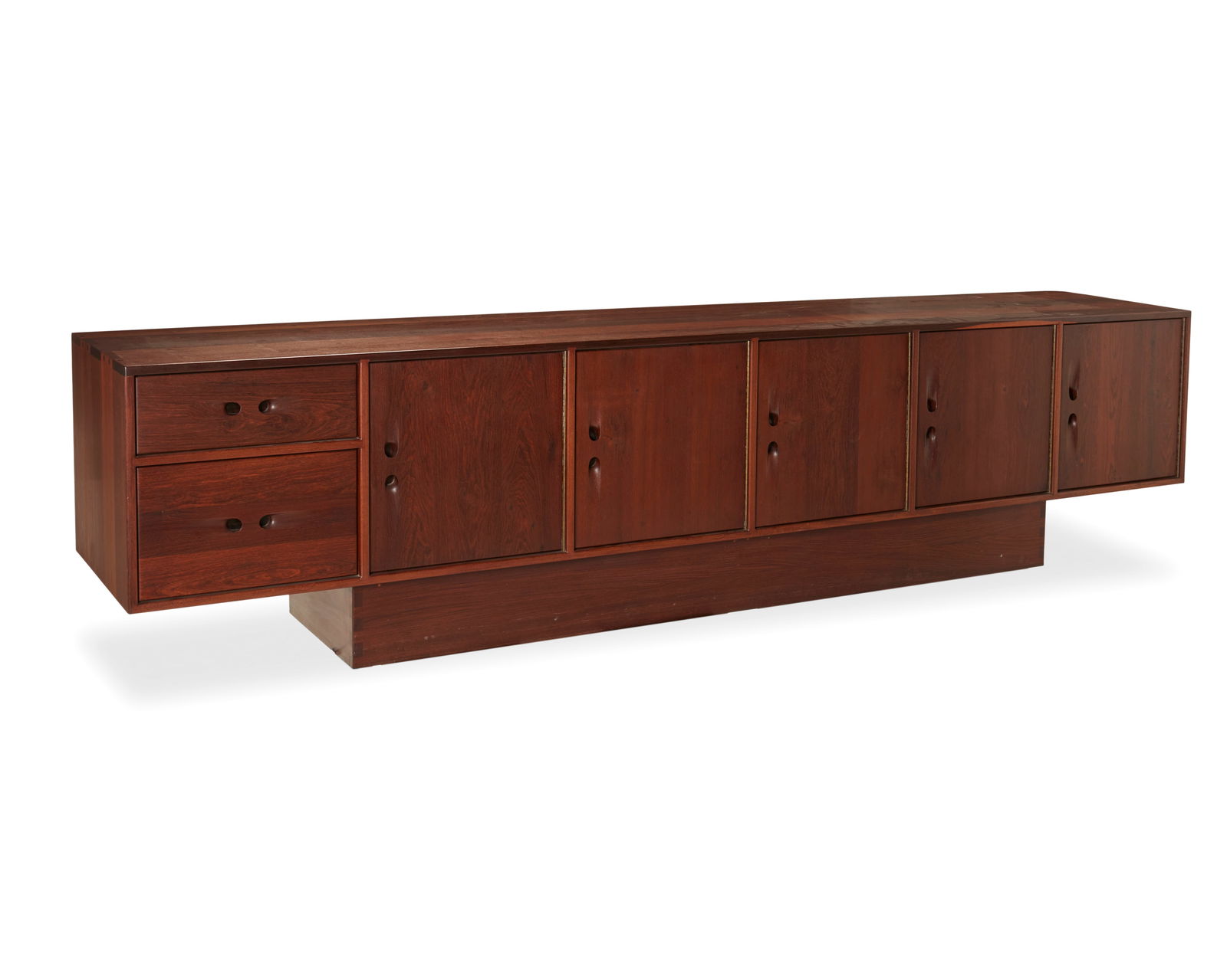 John Nyquist (1936-2018), A Louro Preto credenza, Circa 1972, With base: 27.875" H x 115.325" W x: John Nyquist (1936-2018)A Louro Preto credenza, Circa 1972Designed 1971Marked with the artist's logo incised to the top front cornerThe wood credenza with inset pulls, two drawers and five brass-hinge