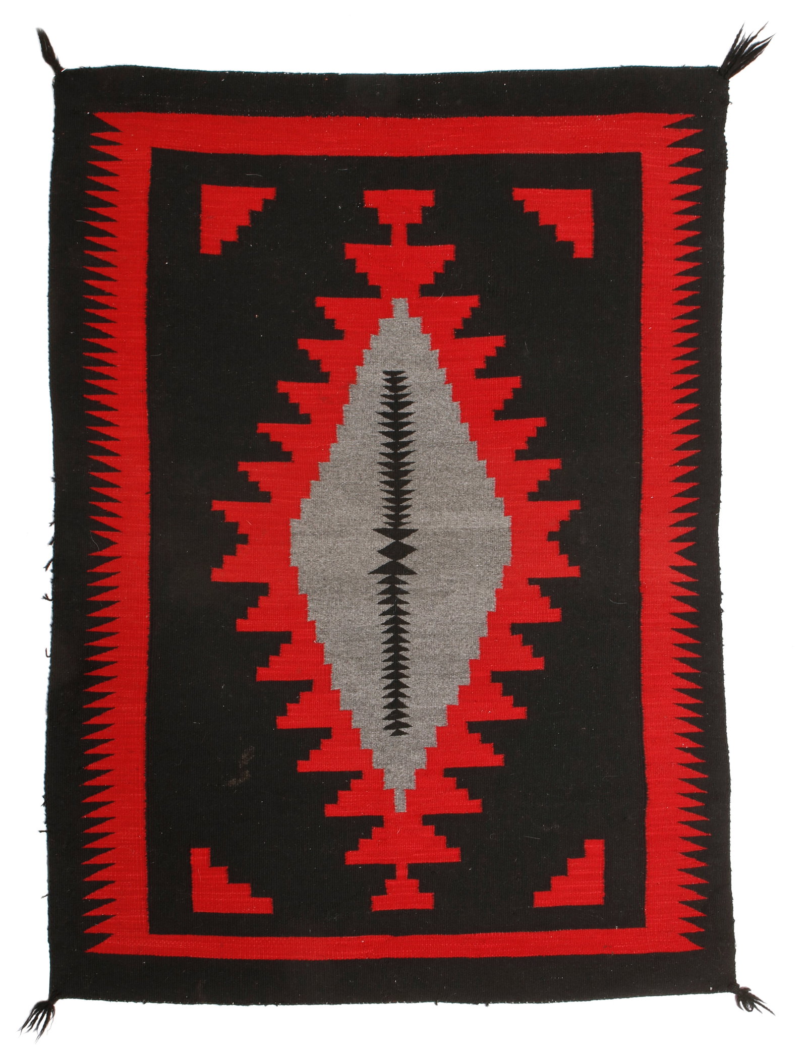 A Navajo regional rug: A Navajo regional rug Mid-20th century, DinE Woven in black red, and grey wool with a central elongated stepped diamond and a sawtooth border 58.5" H x 42.5" W Provenance: Private Collection