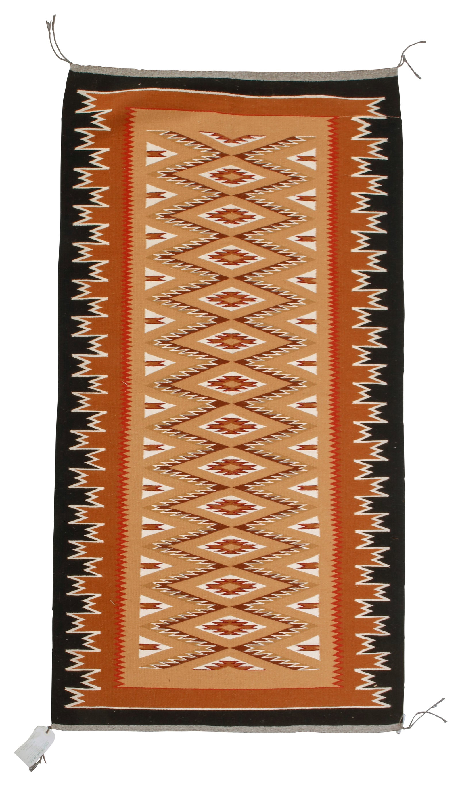 A Navajo Burntwater rug: A Navajo Burntwater rug Late 20th century; DinE Woven in tan, brown, grey, red, cream, magenta and black wool with a central column of serrated diamonds and an elaborate sawtooth border 64" H x 34.5" 