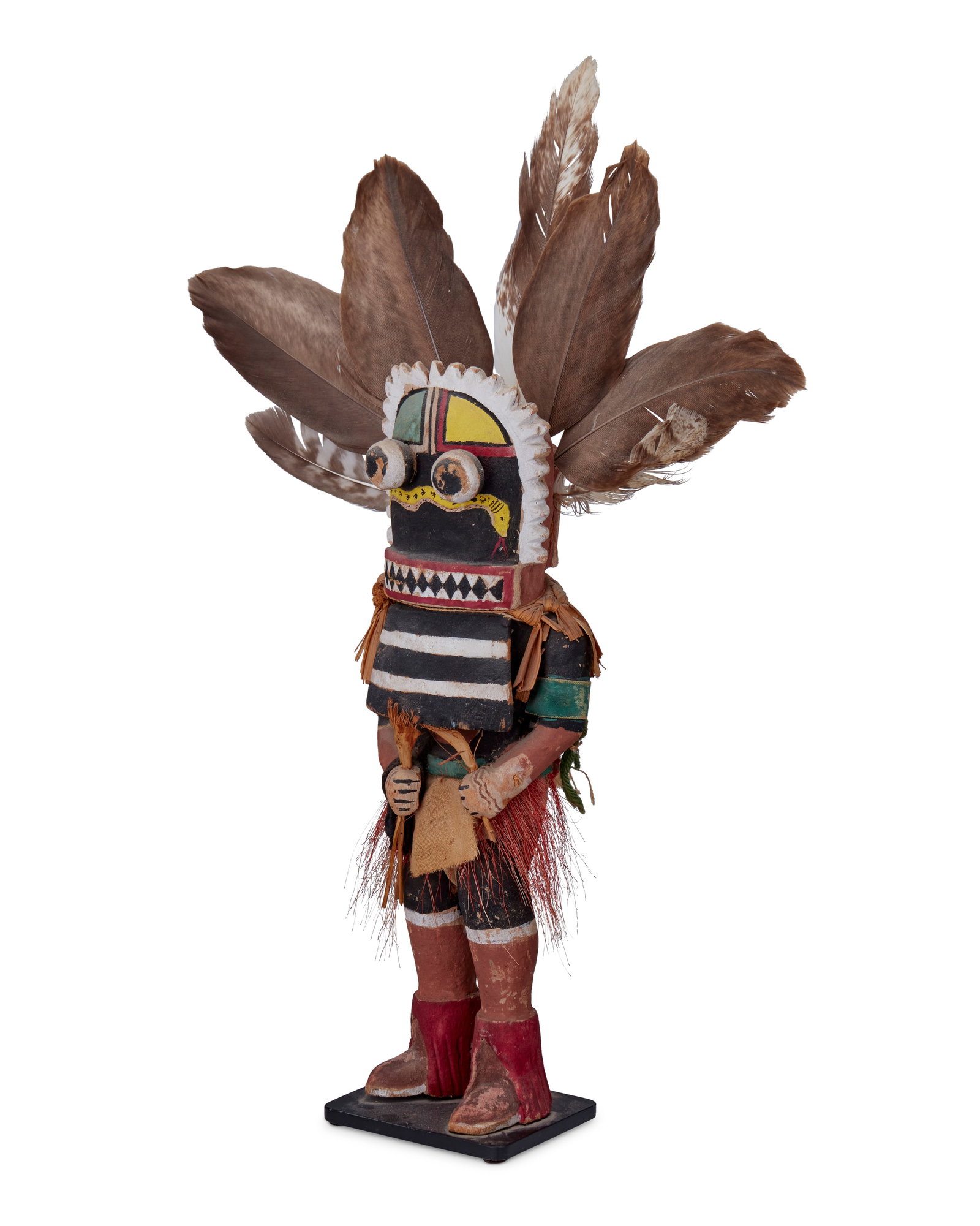 A Hopi Pueblo katsina figure: A Hopi Pueblo katsina figure Mid-20th century A polychrome painted and carved wood "Snake Guard" katsina with feathered mask and round sphere eyes, red fiber skirt, corn husk ruff and leaf b
