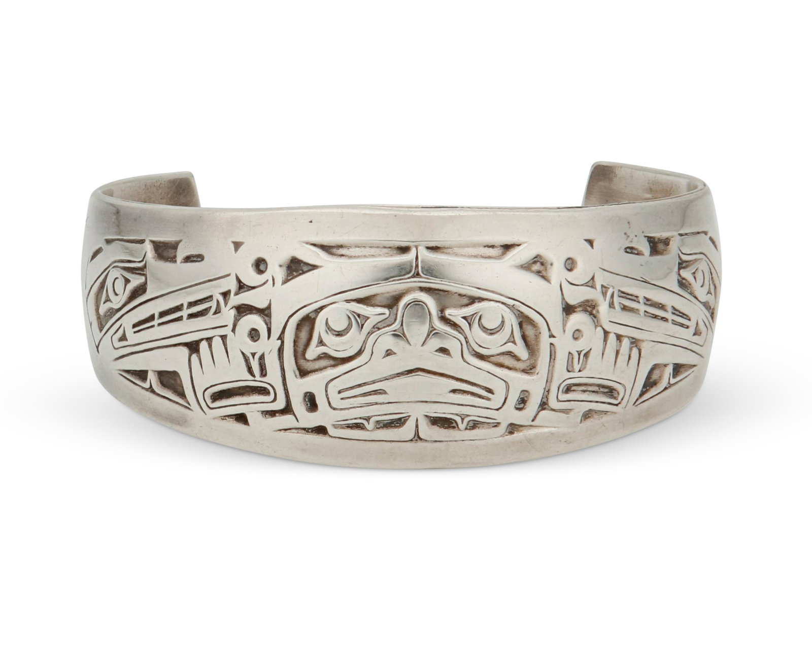 A Northwest Coast sterling silver cuff bracelet: A Northwest Coast sterling silver cuff bracelet Late 20th/21st century Stamped: MAG [for Metal Arts Group] / Sterling An etched silver cuff bracelet with bear and wolf motifs 6.75 " inner C x 1&q