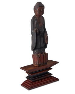 A Korean carved wood Buddha statue: A Korean carved wood Buddha statue18th century or laterThe carved and polychromed wood sculpture of a deity, together with a contemporary wood stand, 2 piecesWithout base: 18.5" H x 5" W x 3.5" D; bas