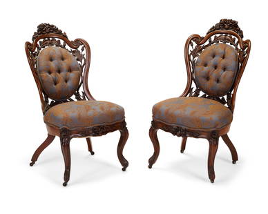 A pair of carved openwork parlor chairs: A pair of Rococo Revival carved openwork parlor chairsMid-19th centuryEach appears unmarkedThe two walnut parlor chairs decorated with carved and openwork roses, acorns, and foliate motifs; the seat c