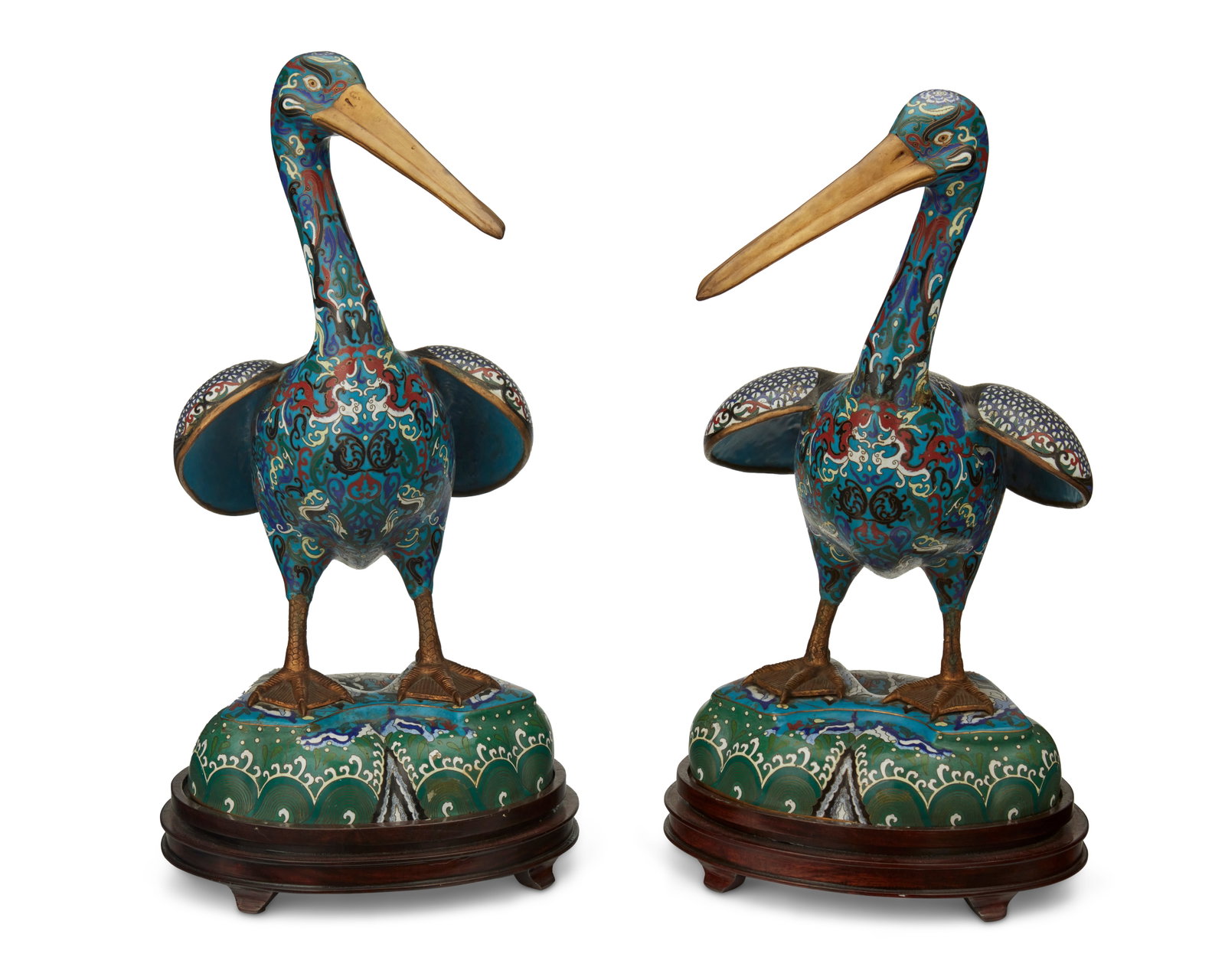 A pair of Chinese brass and cloisonnE pelicans: A pair of Chinese brass and cloisonnE pelicans Mid-20th century Each appears unmarked Each brass pelican with all-over enameled scrollwork and avian motifs and carved, lacquered wood stand, 4 pieces E