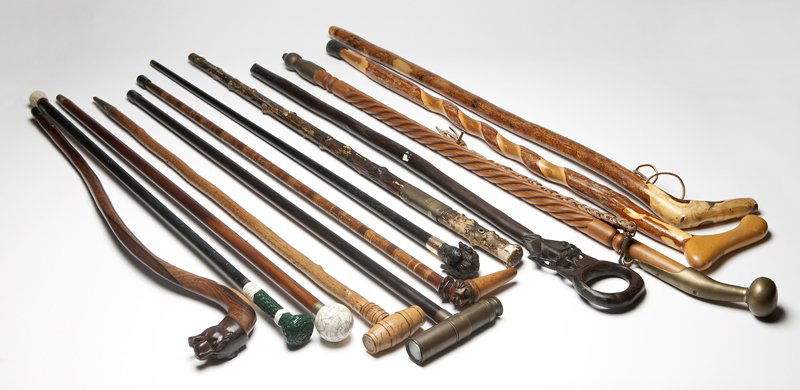 A collection of walking sticks and canes: 19th and 20th century, of various origins, the first: of hand carved wood with a wine barrel-form handle unscrewing to reveal a corkscrew, with brass mount inscribed ''John Walker / 17 Old Court Mansi