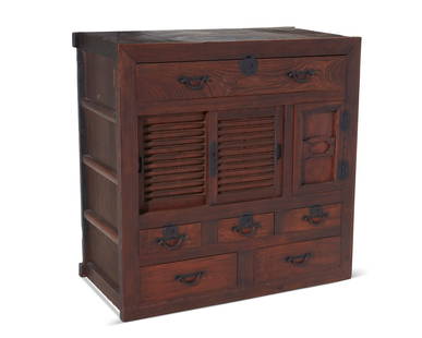 A Japanese tansu-style hardwood cabinet: A Japanese tansu-style hardwood cabinetEarly 20th centuryThe wood cabinet with cast iron hardware, featuring a long drawer above a double sliding door cabinet and hinged door cabinet revealing three s